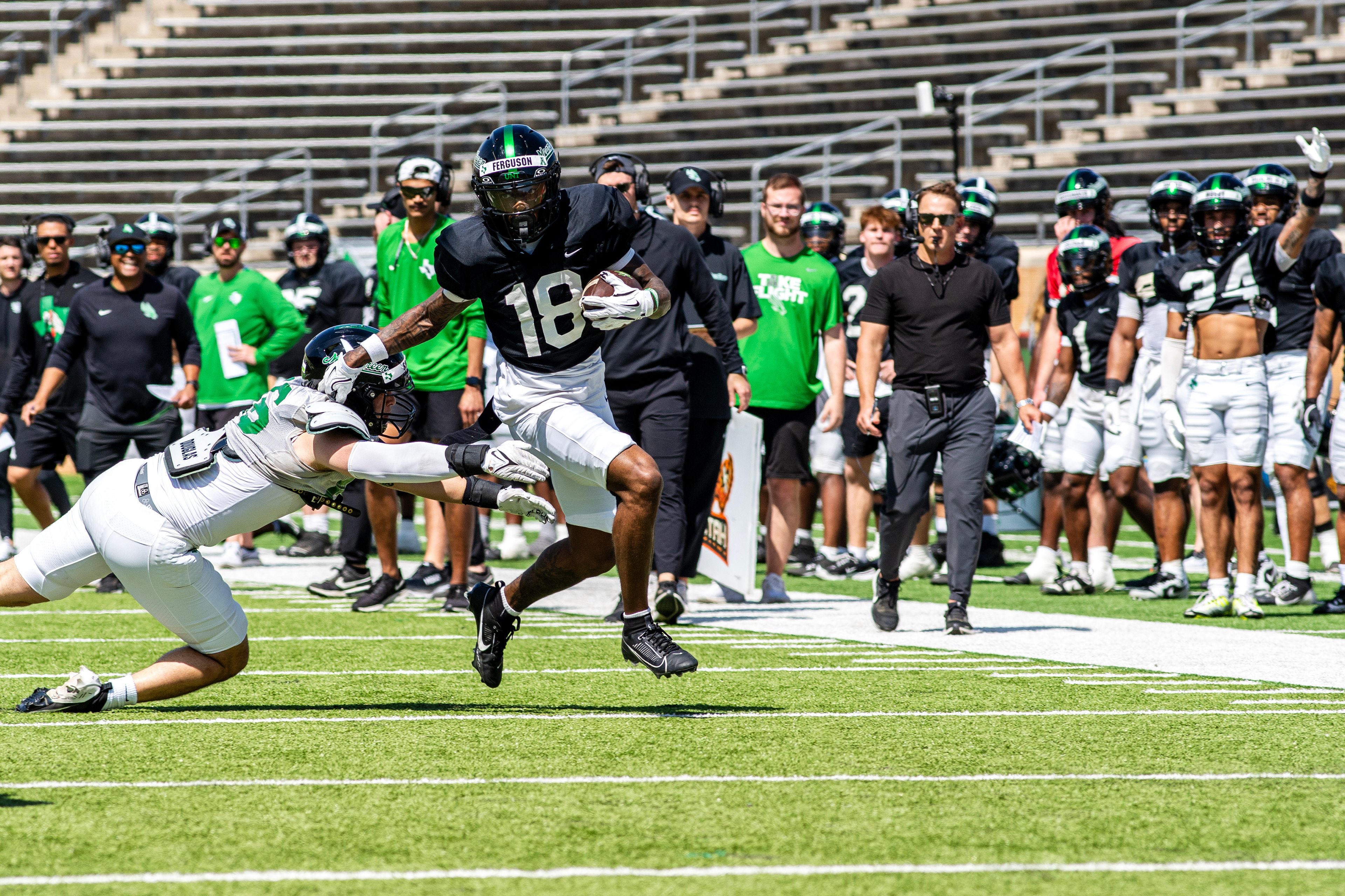 Getting North: Freshman wide reciever Mason Ferguson evades a defender during UNT's scrimmage at DATCU Stadium.