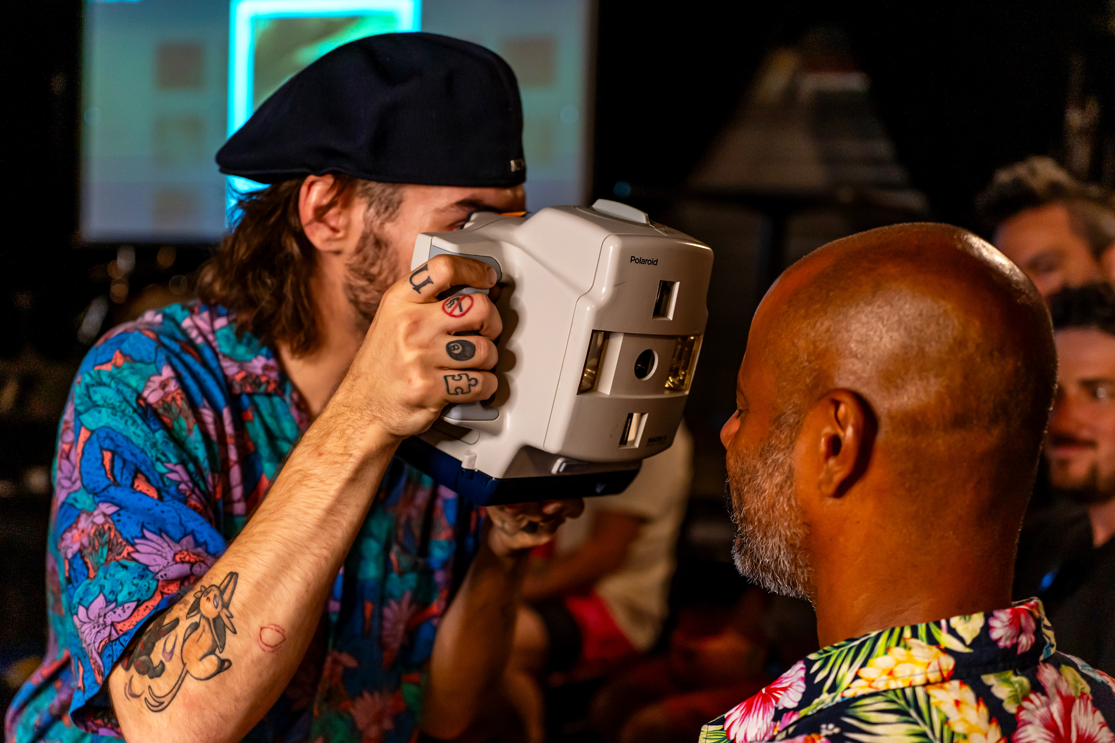 From left: Nick Mass takes a Polaroid of Lou Noble during Mass' Macro 5 SLR workshop at Rubber Gloves during Polacon in Denton, TX on Sept. 27, 2025. A Macro 5 SLR Polaroid was originally used for dental work, allowing dentists to take Polaroids of teeth close up. 
