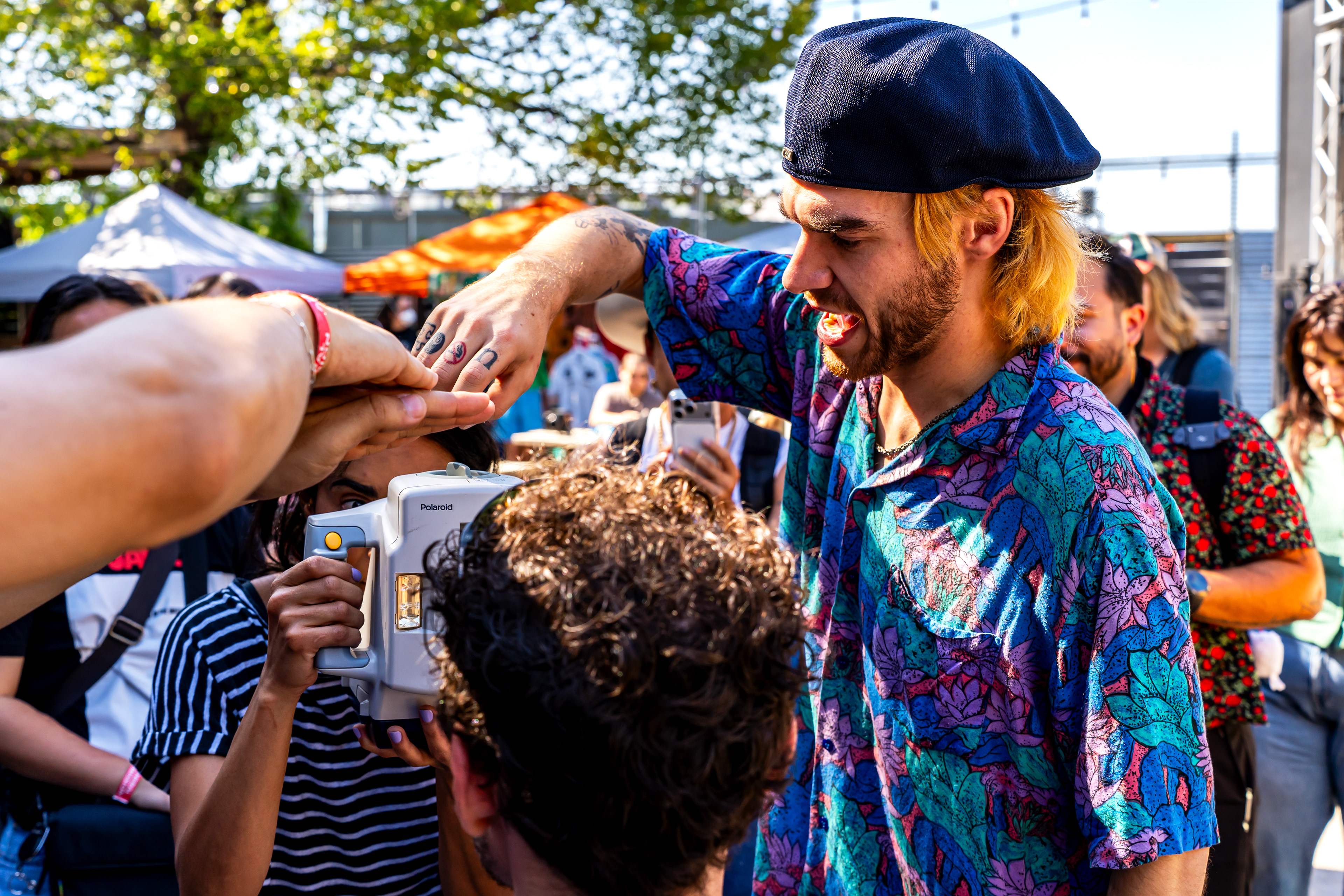 Nick Mass shows an attendee how to take a Polaroid with his Macro 5 SLR Polaroid during Mass' Macro 5 SLR workshop at Rubber Gloves during Polacon in Denton, TX on Sept. 27, 2025.