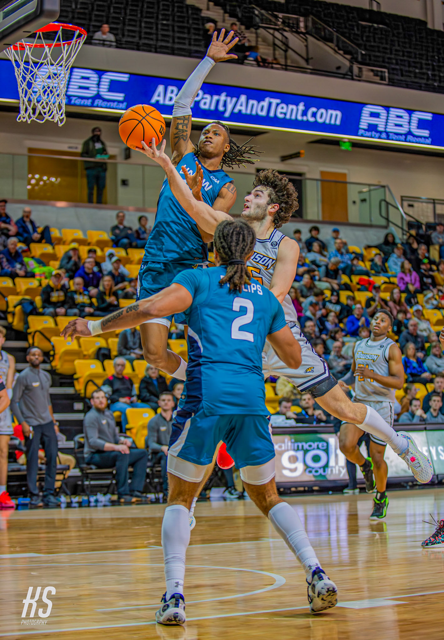Towson University Men's Basketball forward Christian May attempts a challenging layup against conference rival University of North Carolina Wilmington Men's Basketball forward Trazarien White during the game at TU Arena in Towson, MD, on January 6, 2024.