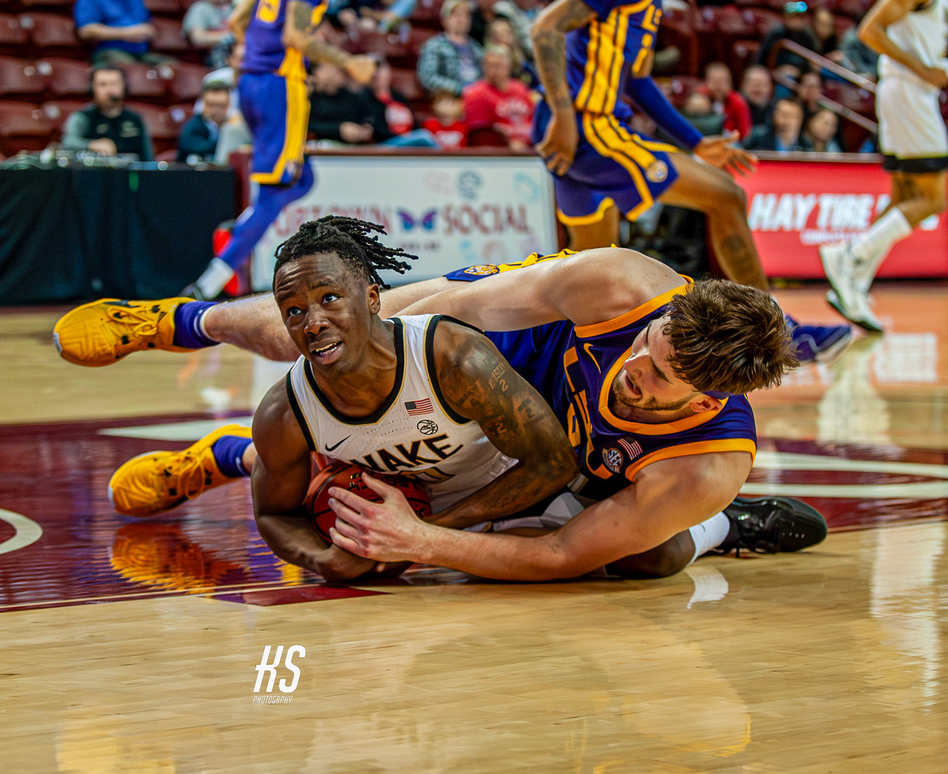 Wake Forest University Men's Basketball guard Kevin Miller struggles for the ball against Louisiana State University Men's Basketball forward Will Baker during the Charleston Classic at TD Arena in Charleston, SC, on November 19, 2023.