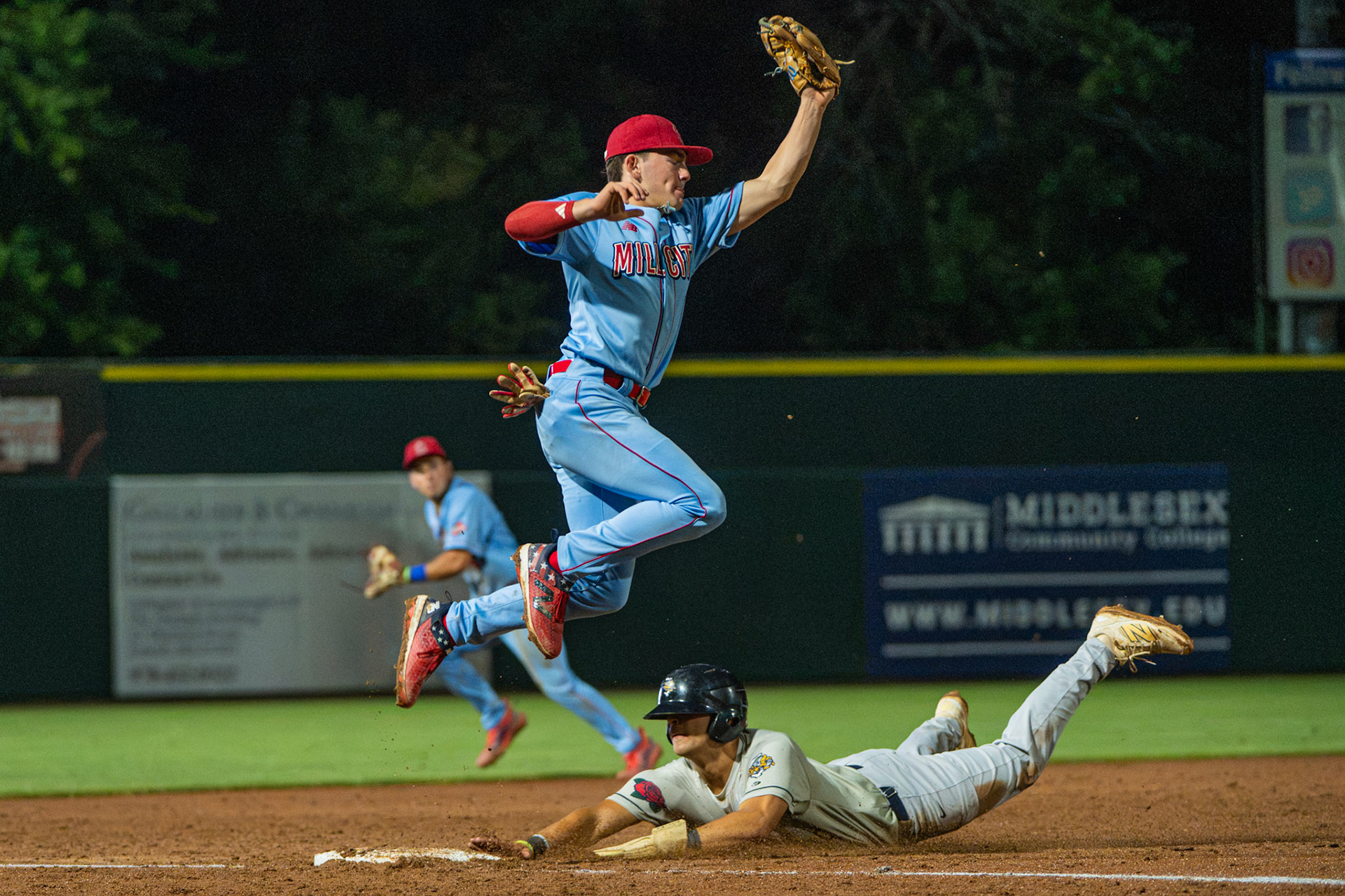 Lowell Spinners' shortstop Quincy Kerr makes a leaping catch while his Norwich Sea Unicorn opponent dives to third base. The game was played at Edward A. LeLacheur Park in Lowell, MA, on July 28th, 2026.