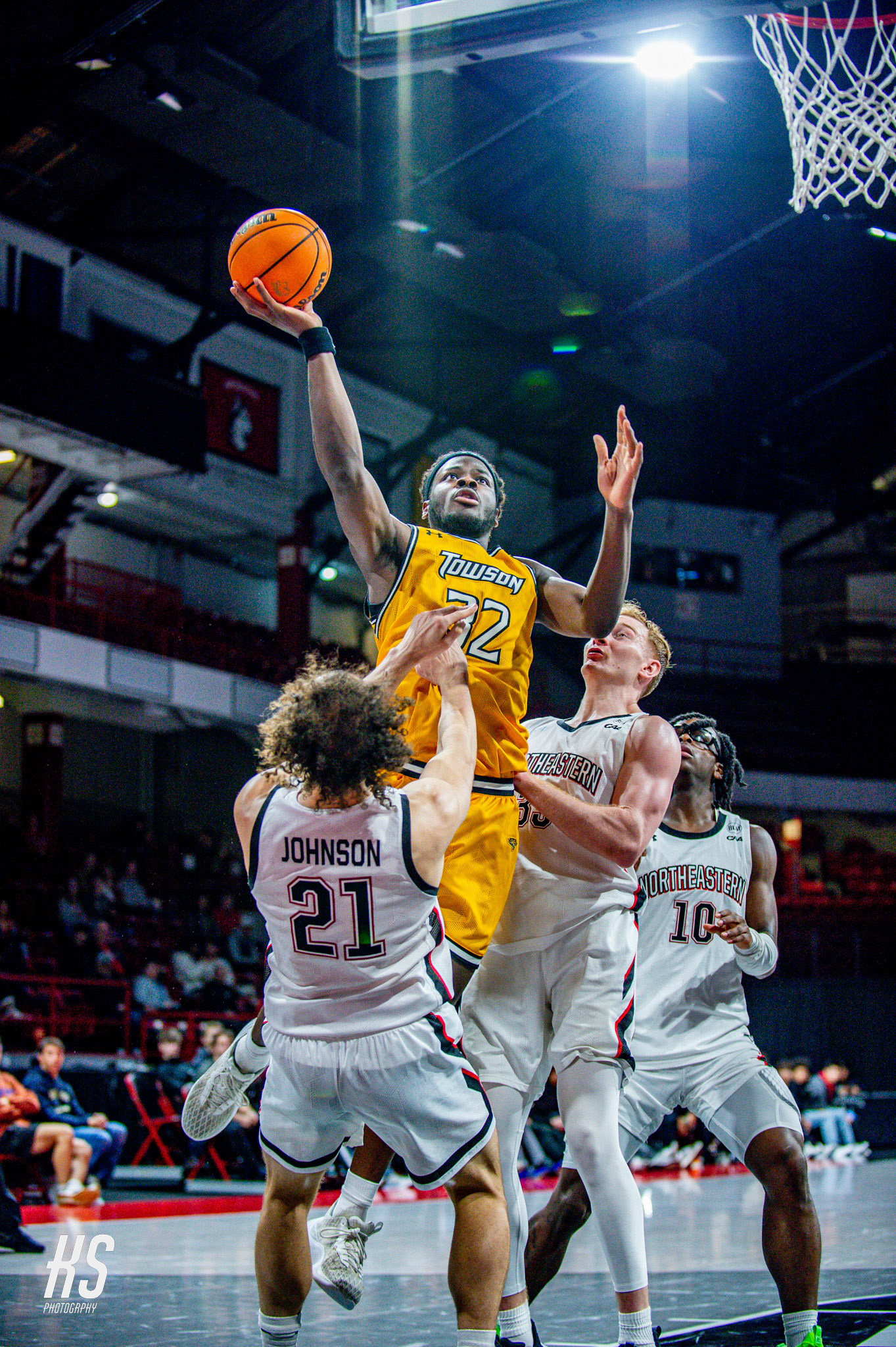Towson University Men's Basketball center Charles Thompson scores a powerful layup against conference rival Northeastern University Men's Basketball forward Bryce Johnson during the game at Matthews Arena in Boston, MA, on January 13, 2024.