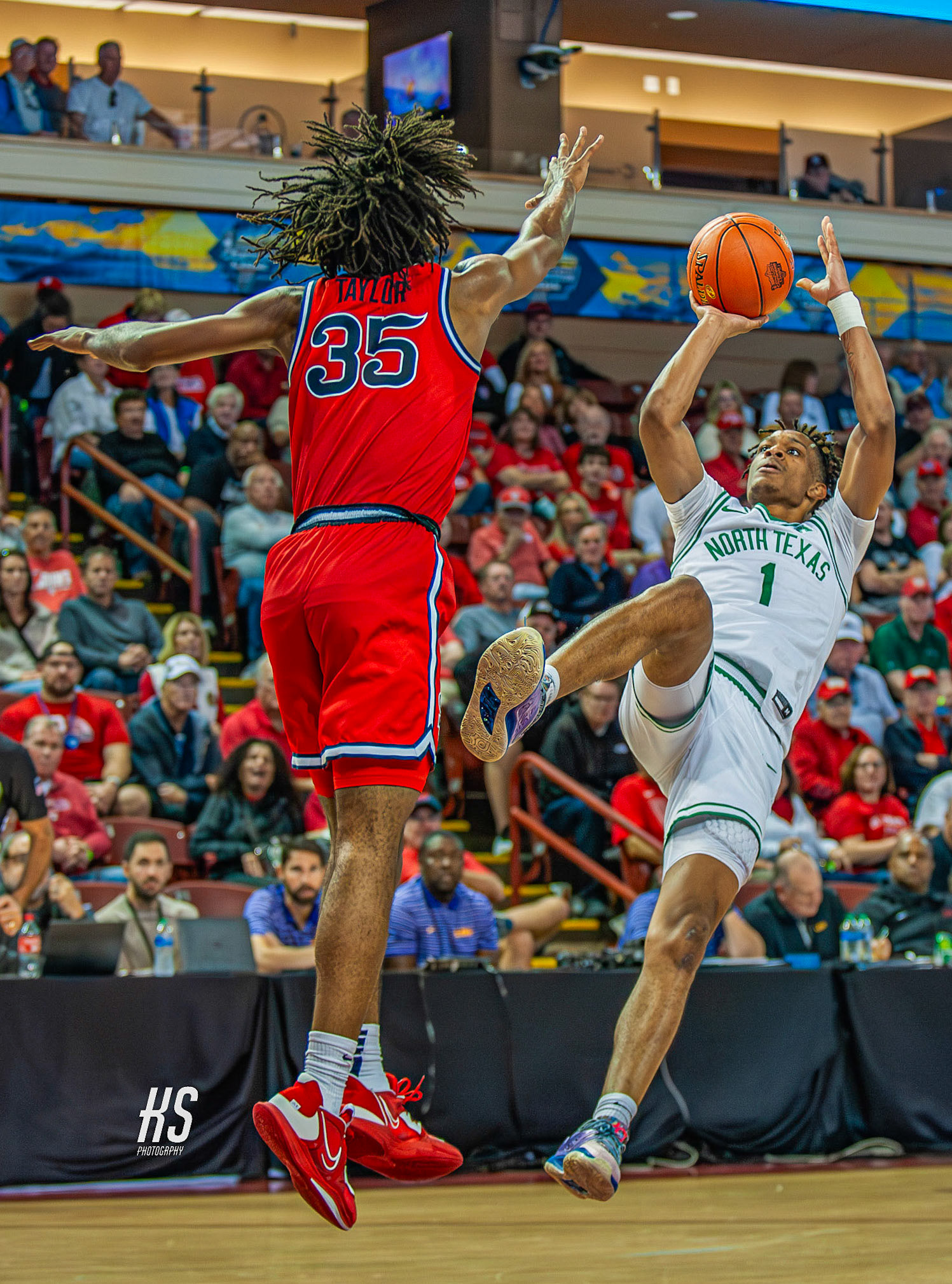 University of North Texas Men's Basketball small forward Aaron Scott Jr. shoots a difficult jump shot while tightly guarded by St. John's University Men's Basketball forward Glen Taylor Jr. during the Charleston Classic at TD Arena in Charleston, SC, on November 16, 2023.