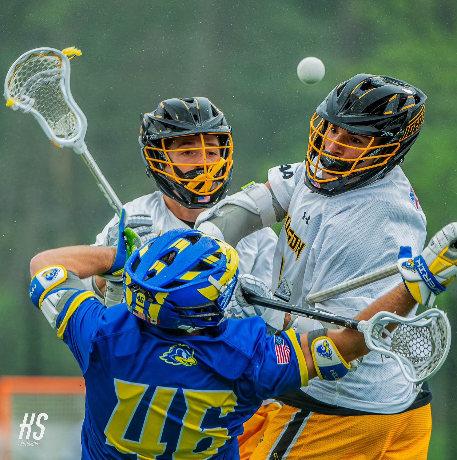 Midfielders Mikey Weisshaar and Josh Webber of 15th-ranked Towson University Men's Lacrosse knock the ball loose from a 19th-ranked University of Delaware opponent during the 2024 Coastal Athletic Association Men's Lacrosse Championship at Unitas Stadium in Towson, MD, on May 4, 2024.