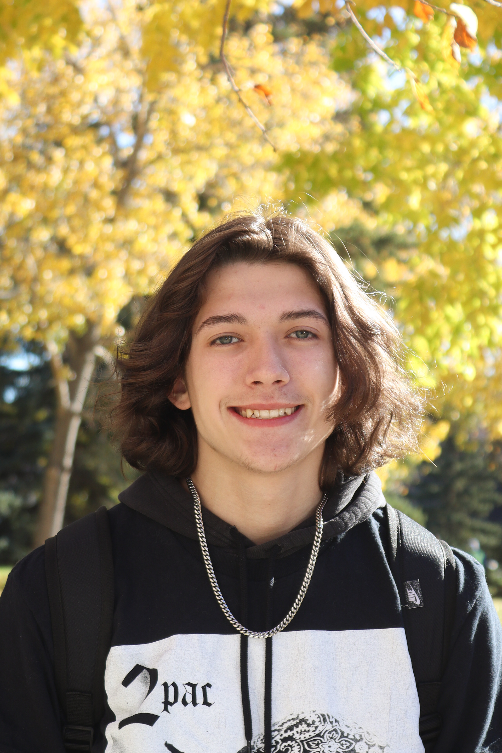 Subject posed in front of fall leaves