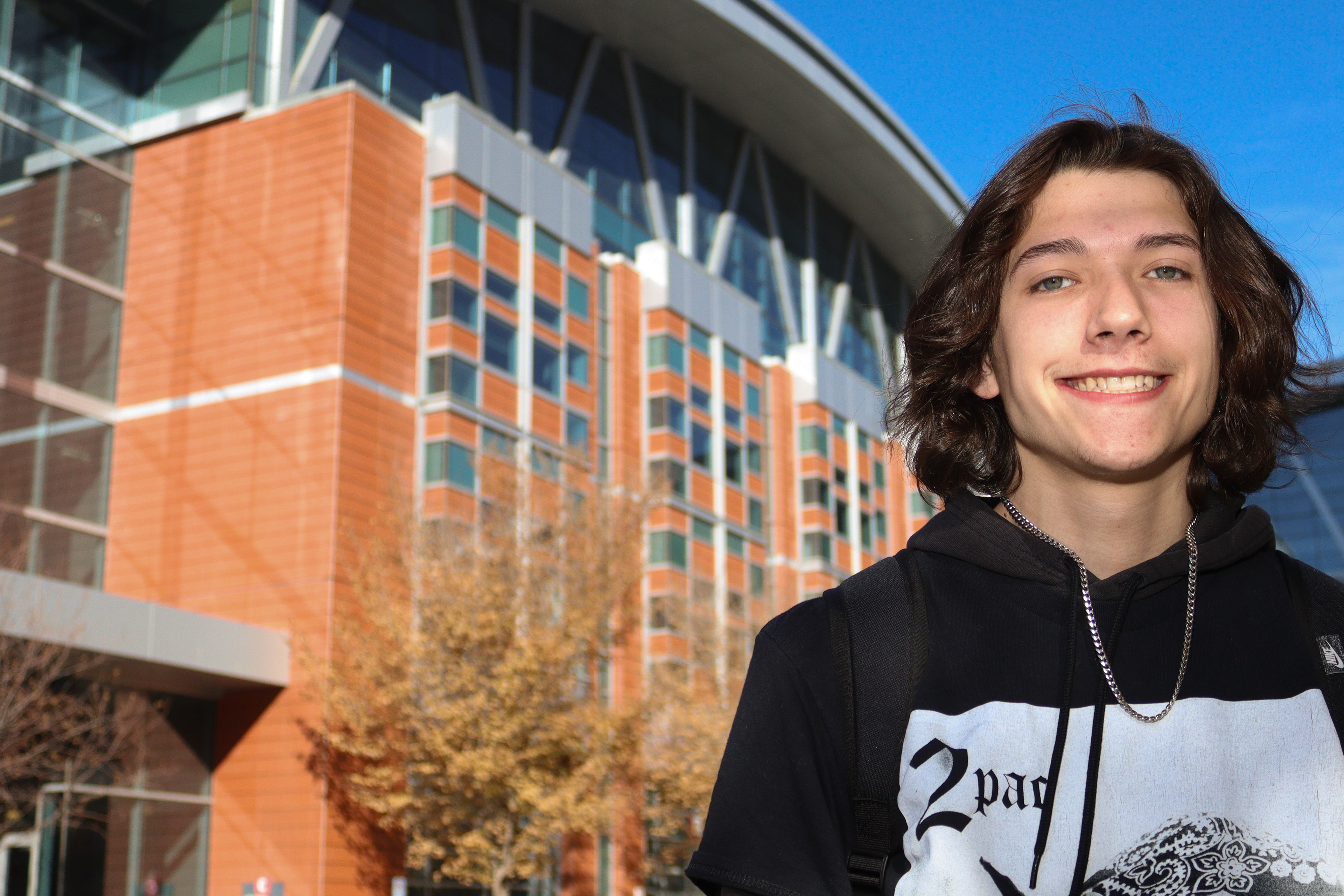 Subject stands in front of university building