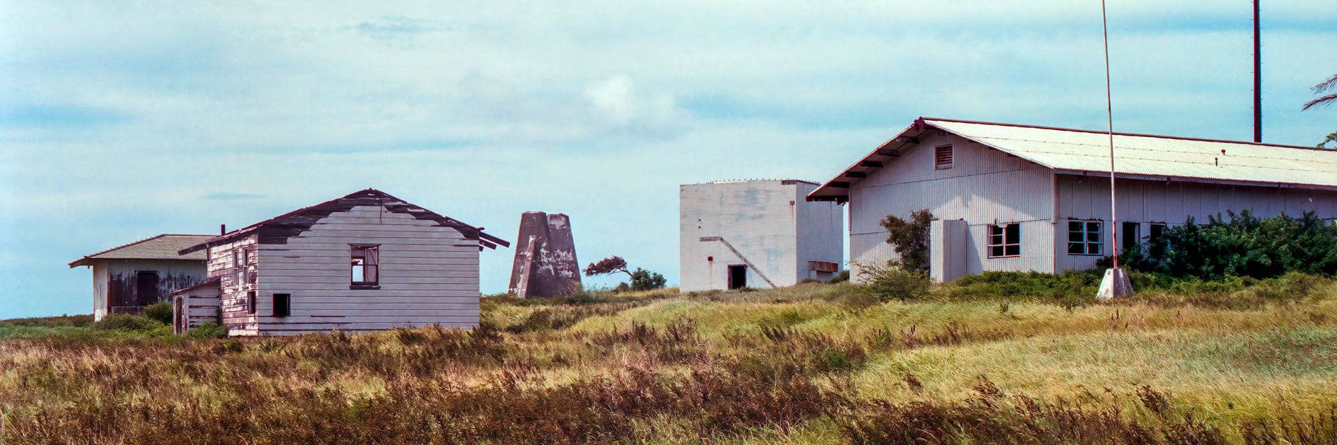 An abandoned building, a remnant of the US Air Force base (Morse Field) built during WWII on the Island of Hawaii, sits exposed to the elements on the grassy meadow above the Ka Lae cliffs.Image captured on Kodak Royal Gold 100 color negative film. After scanning it with an Epson Perfection V750 PRO using Silverfast software, the ColorPerfect Plugin from CFSystems converted the negative image to a positive image in Photoshop. Post-processing completed in Lightroom Classic.