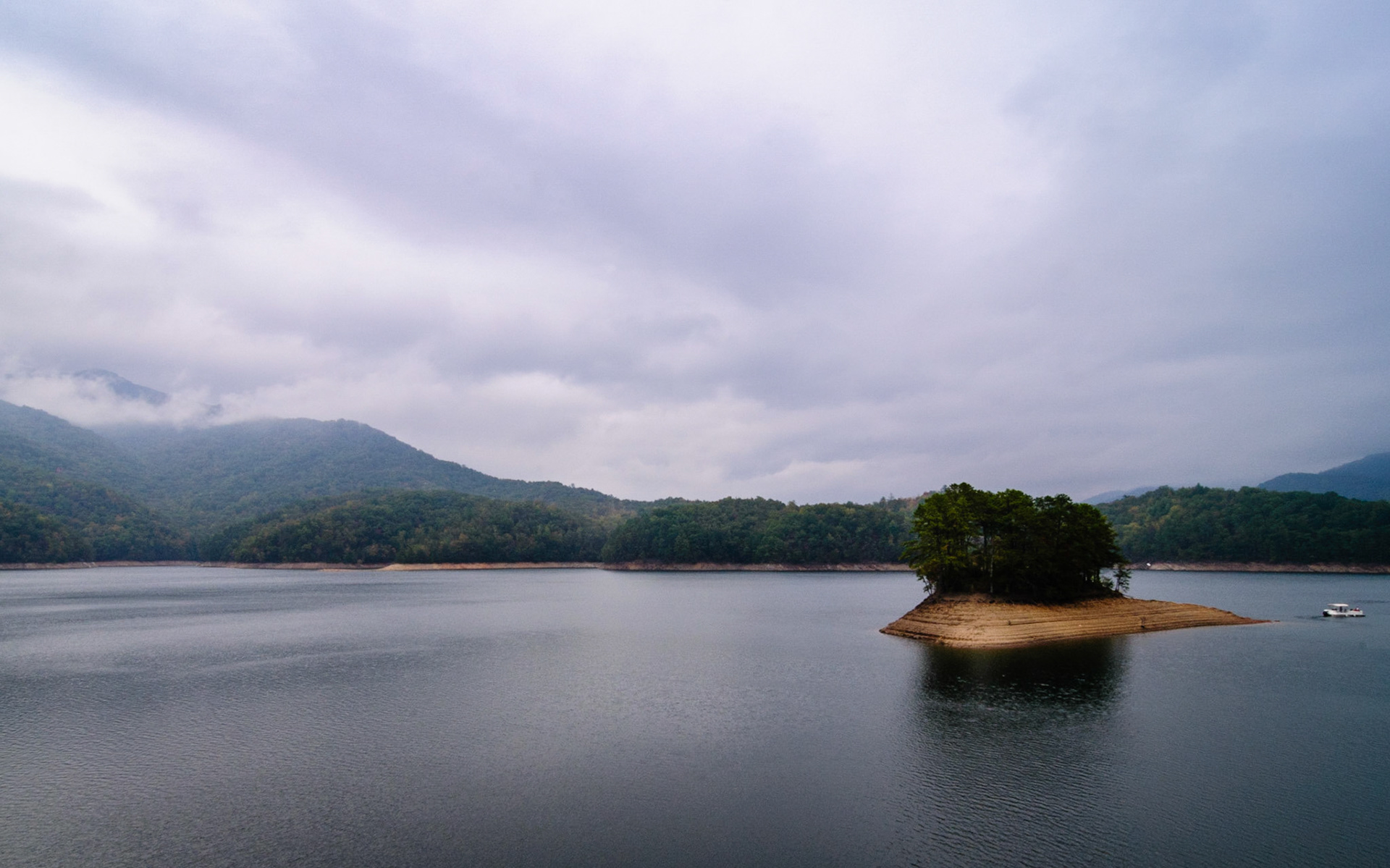 Fontana Lake is a 10,230 acre (4,140 ha) lake created by the Fontana Dam, which is located in Swain and Graham Counties on the Little Tennessee River in North Carolina, and it impounds 1,443,000 acre feet (1.780 km³) of water. This photo was made from the top of the dam when the lake was at a low pool. A portion of the southwestern boundary of the Great Smoky Mountains National Park is pictured here, and the Appalachian Trail crosses the top of the dam.