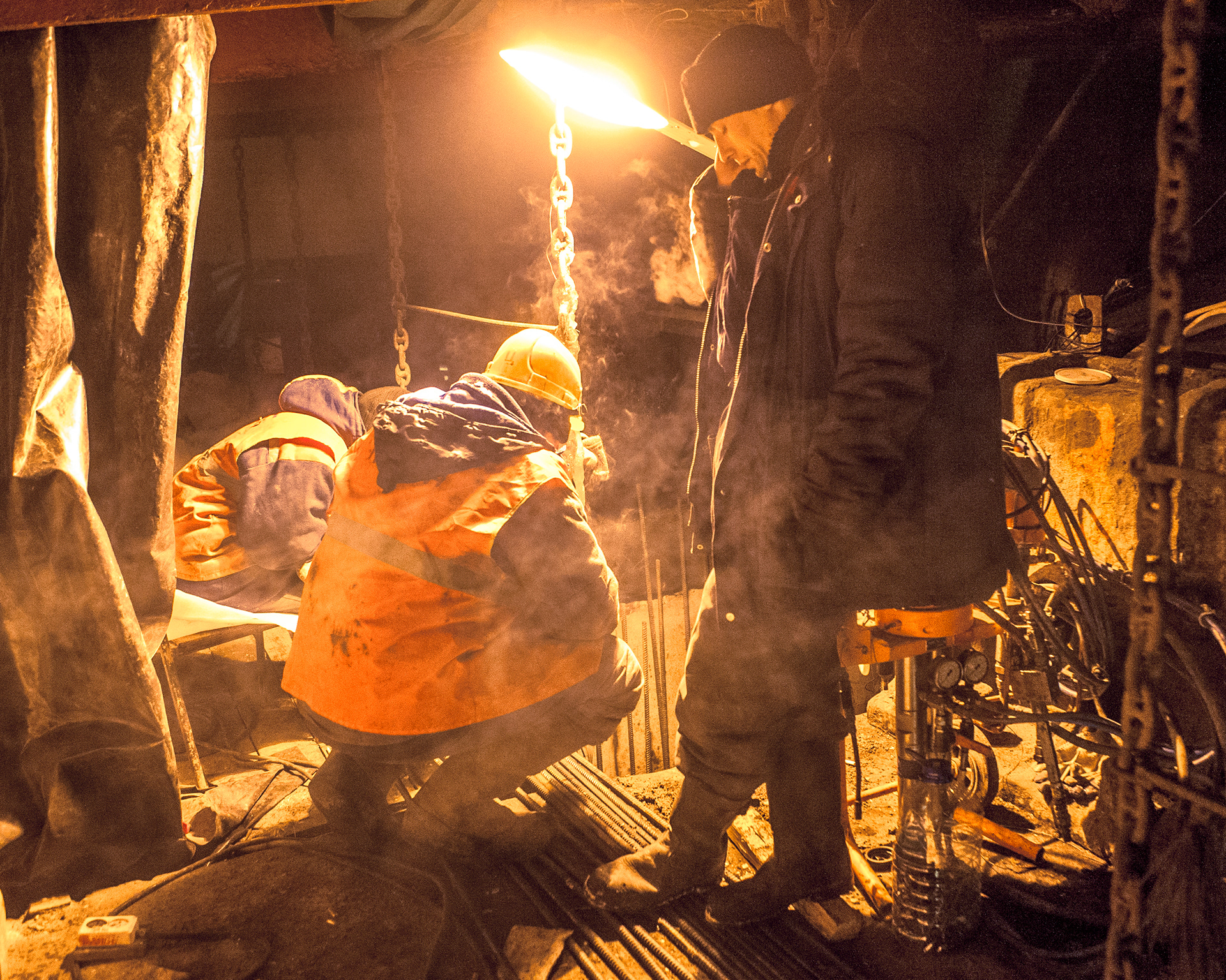 Workers are pouring concrete into the bridge support. January, very cold. A smoke break