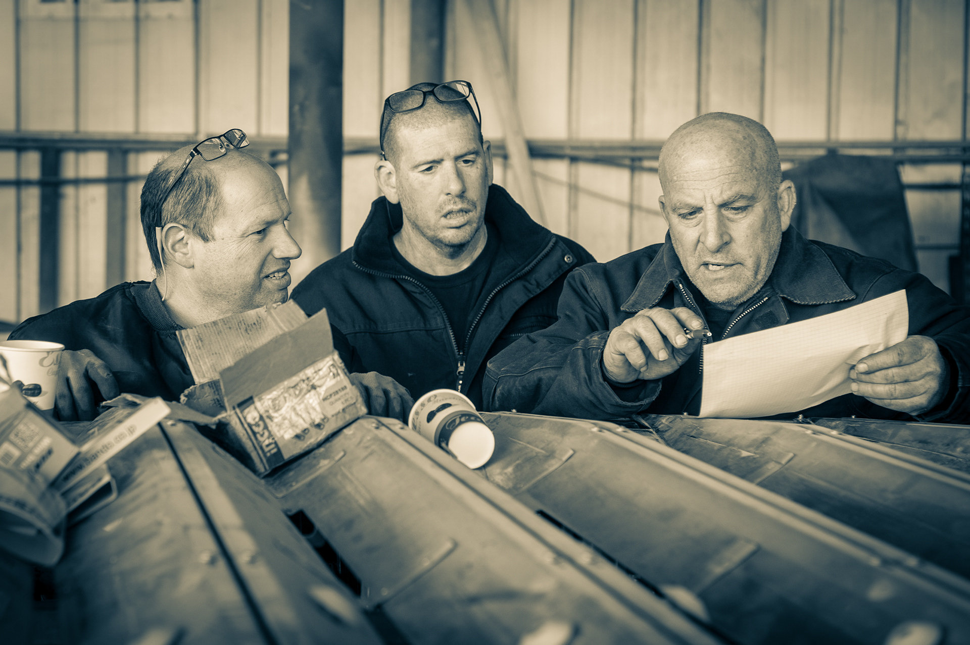 Manager with workers are planning repair of date sorting machine