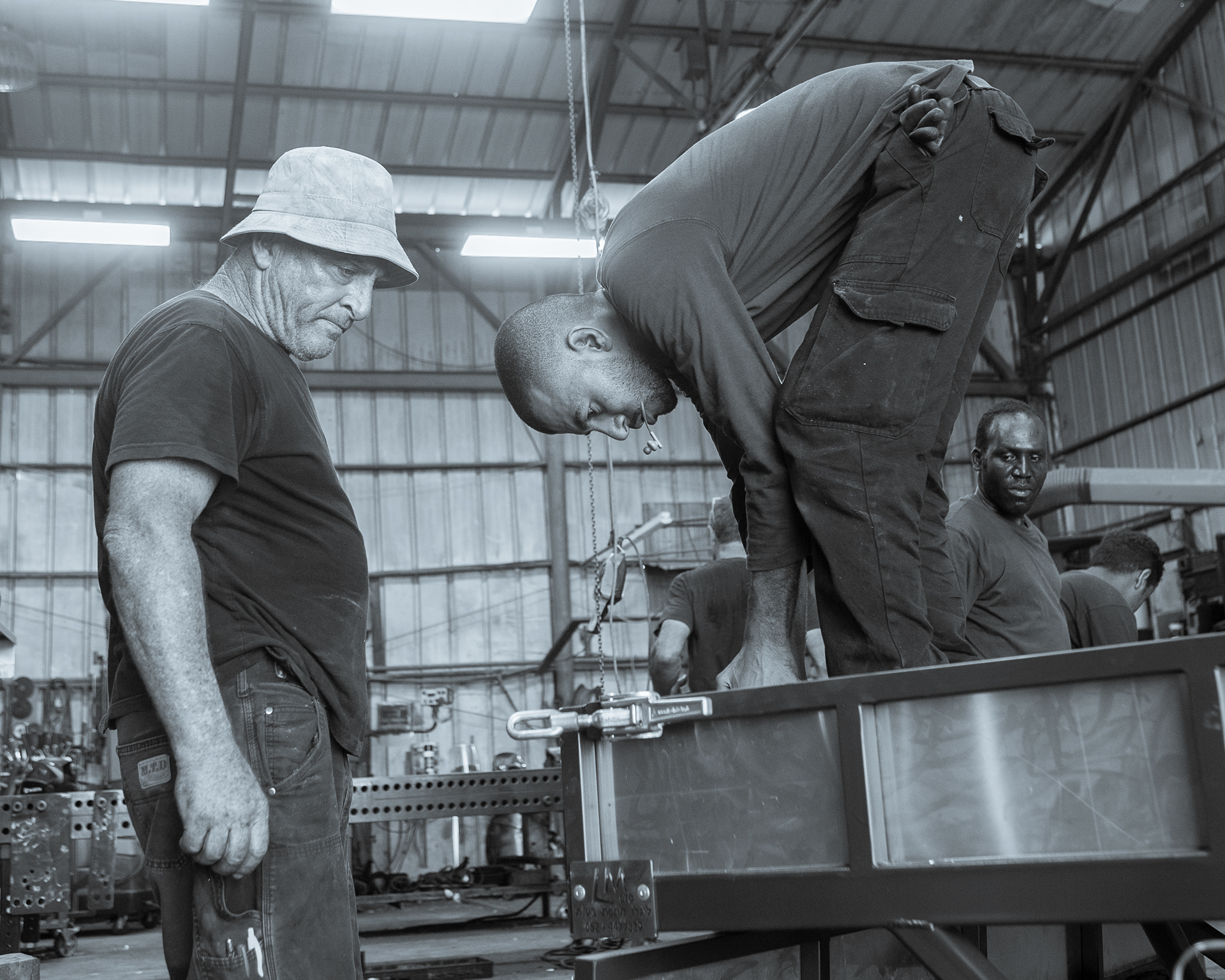 Israeli locksmiths: a jew, a bedouin and a sudanese are repairing a car trailer
