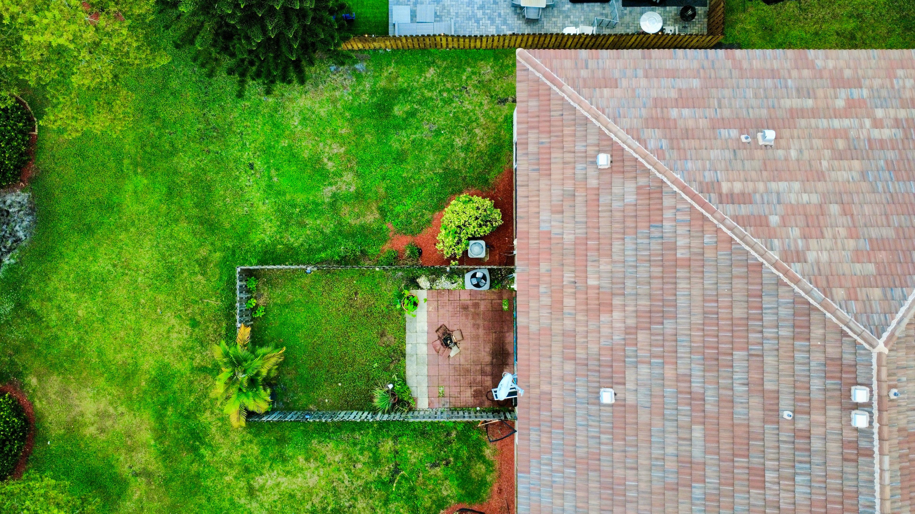 Private fenced backyard with patio space captured from above to showcase layout and usable outdoor living.