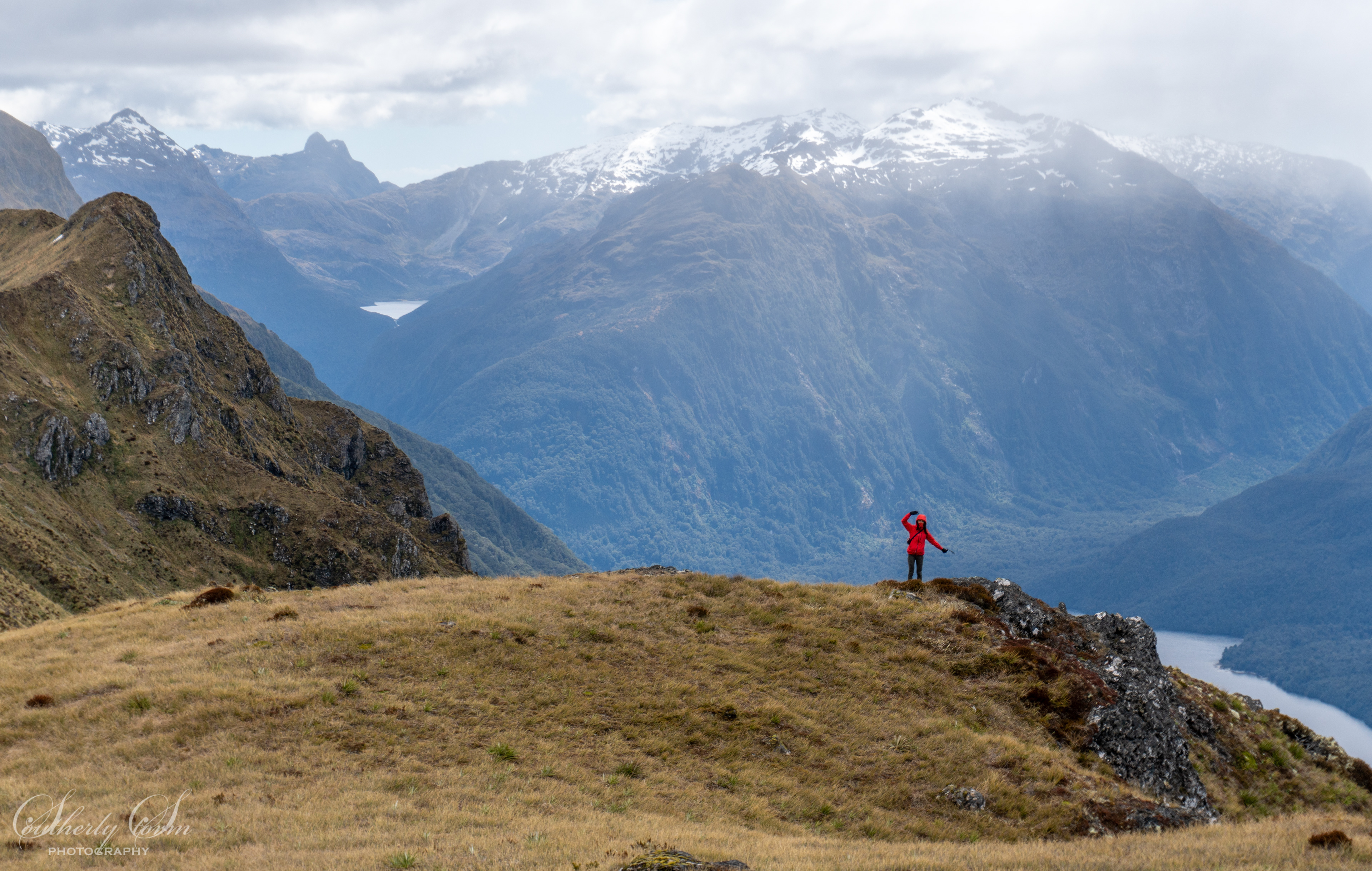 Tramper in front of a view of Lake Te Anau