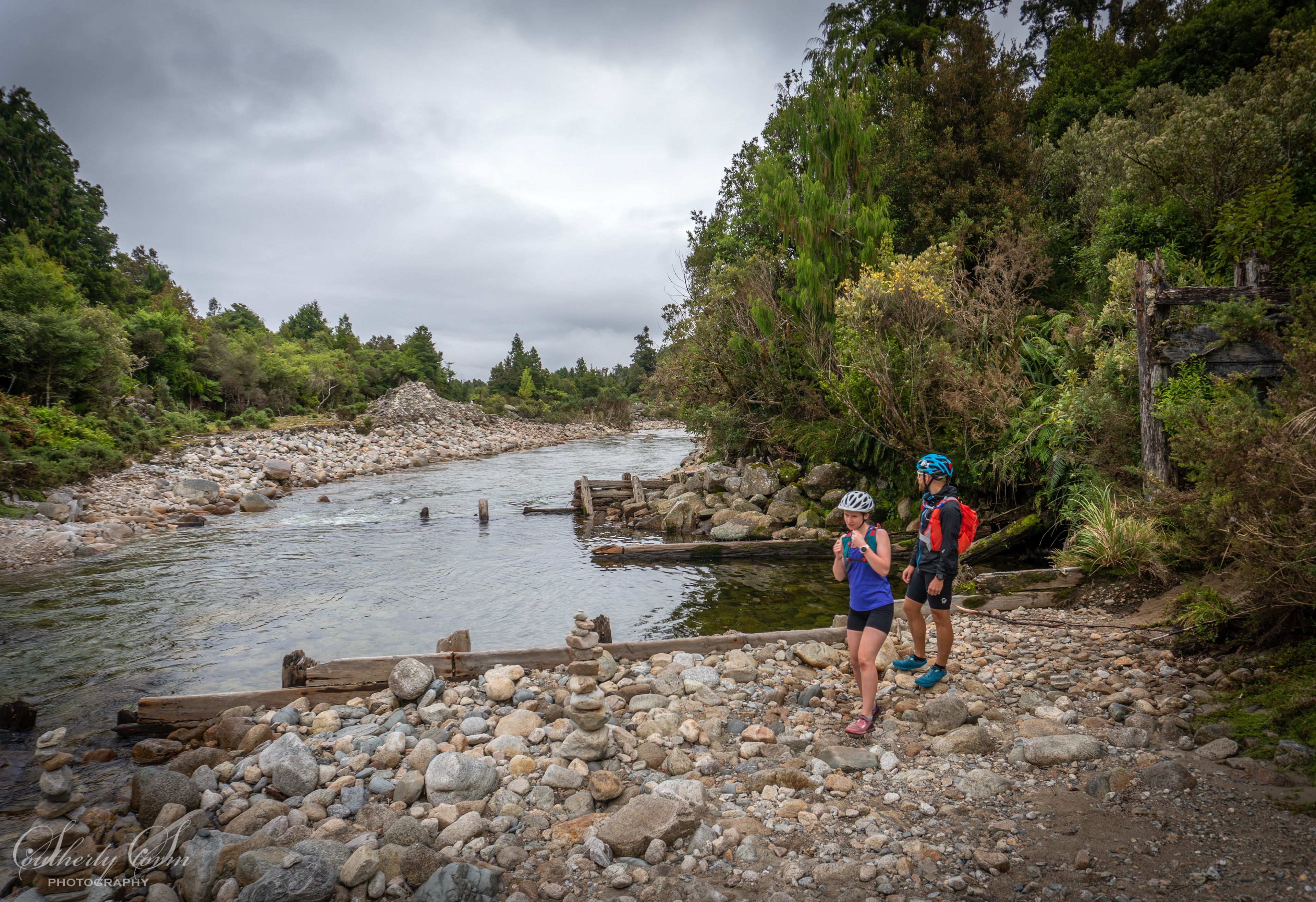 Two people by an historic dam on a river