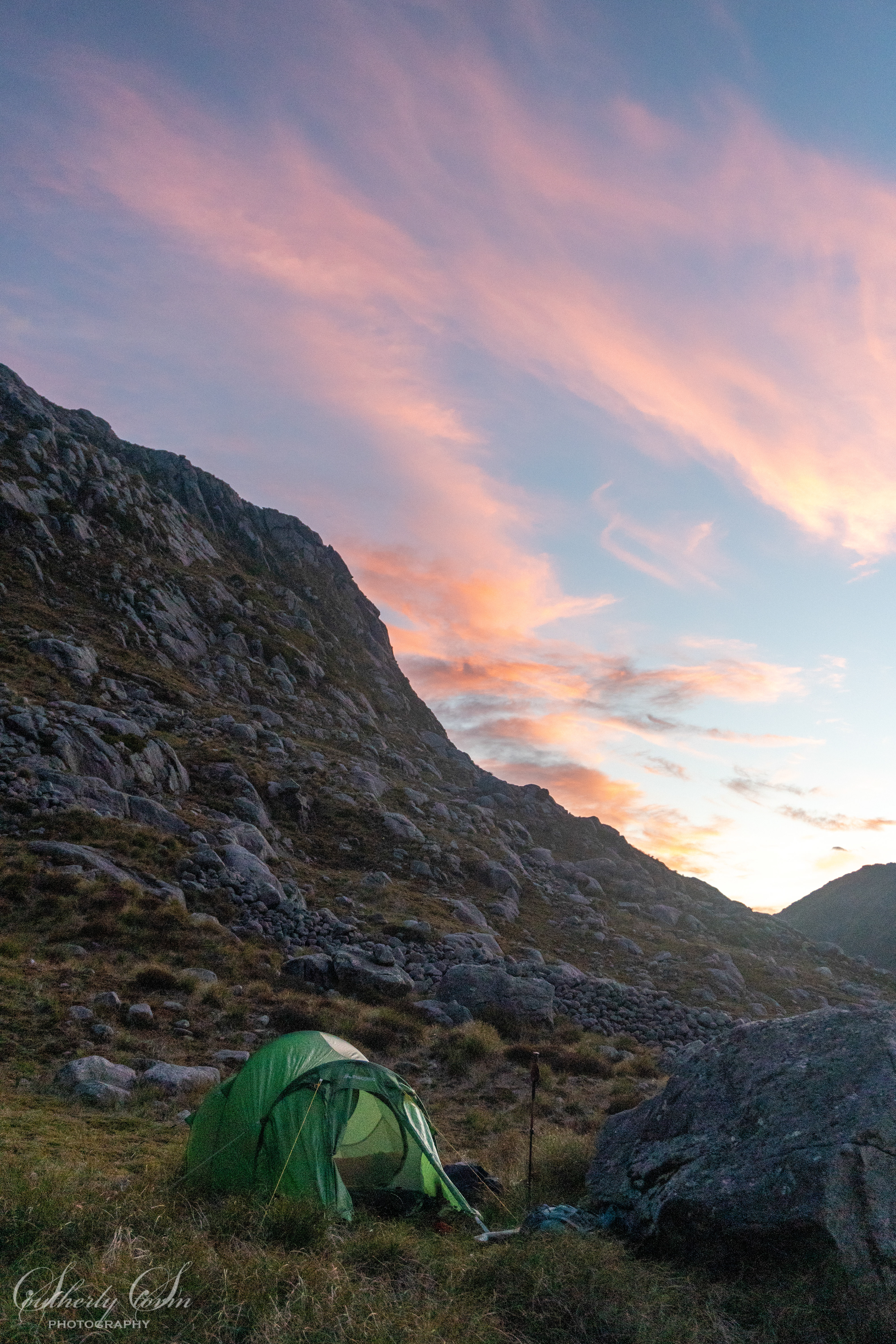 Tent in the foreground pink clouds in the sky