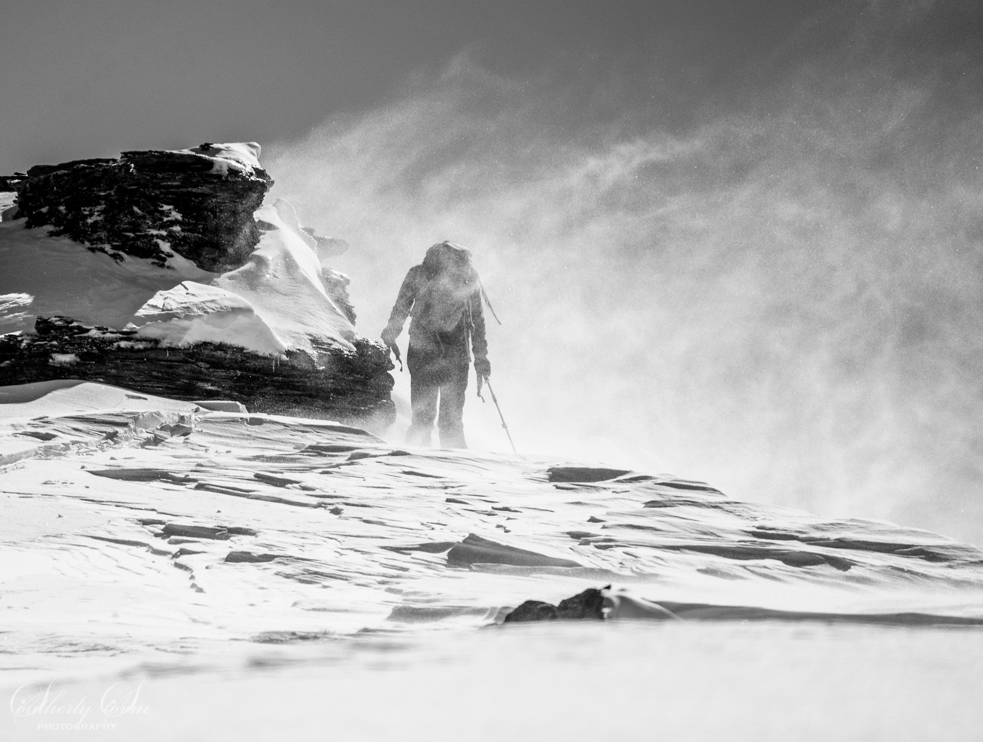Skier on a windy ridge line in black and white