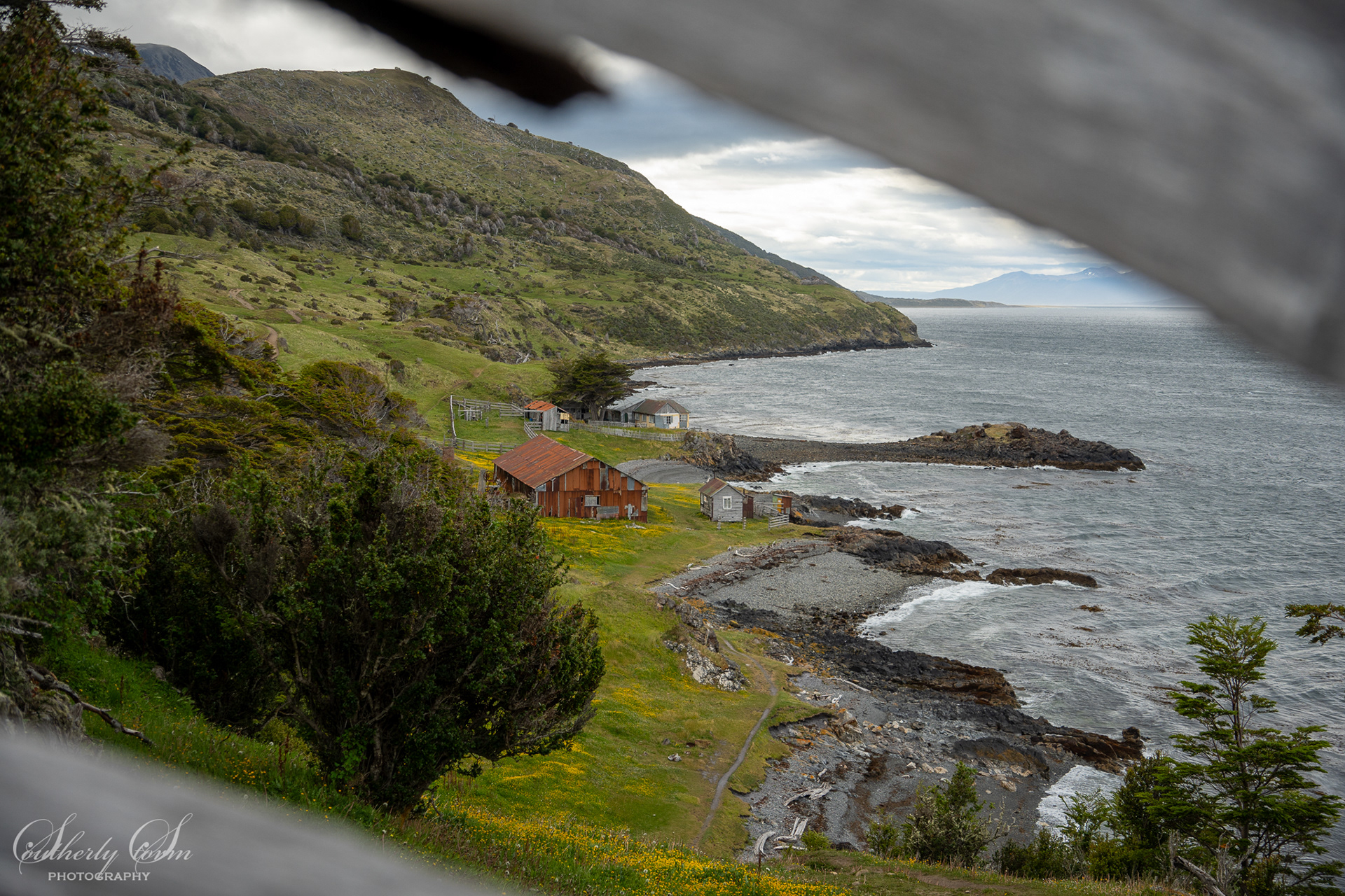 Costal farm Ushuaia taken through a fence