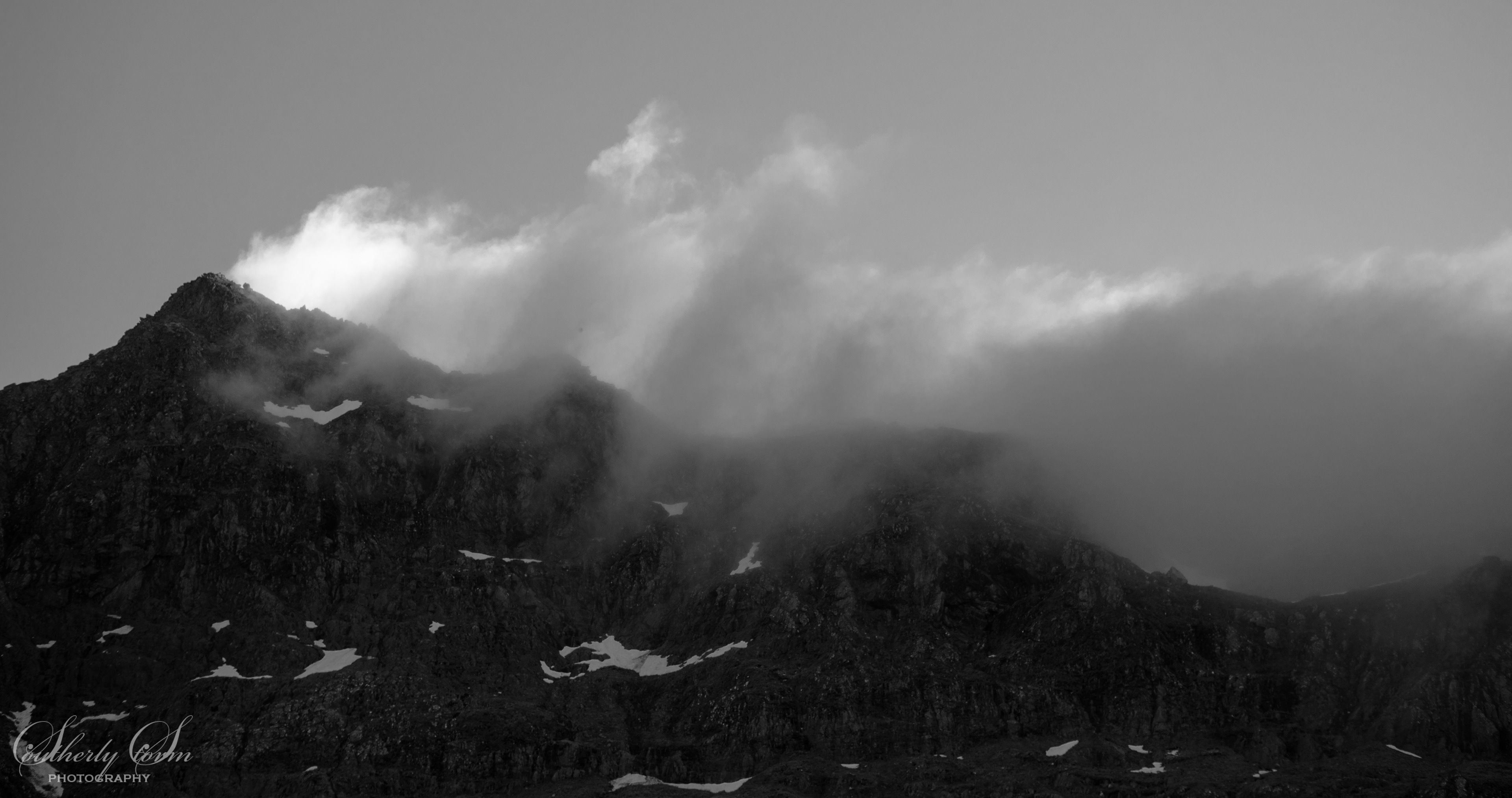 Black and white photo of mountains and clouds