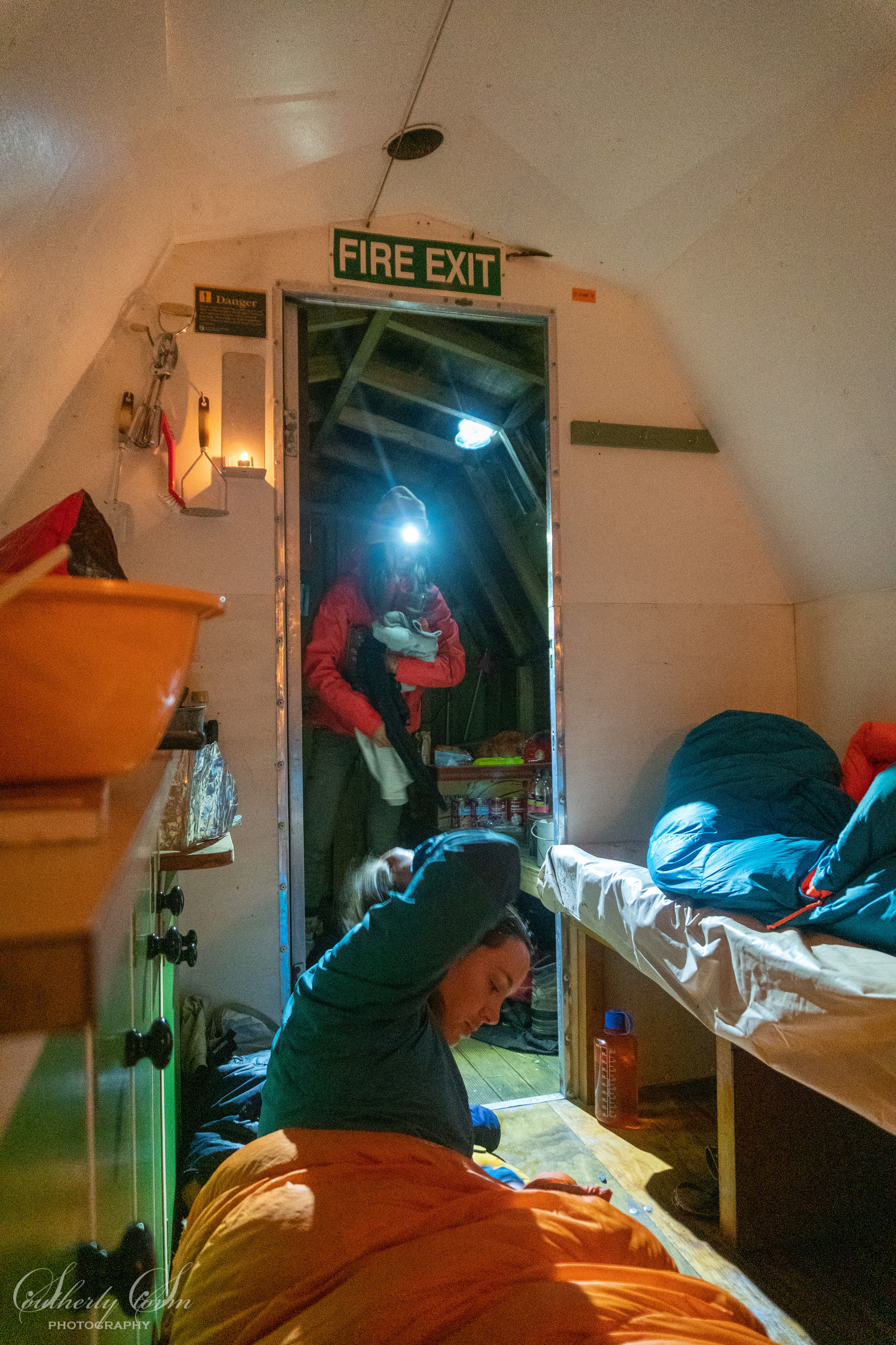 Trampers get ready for bed in a hut