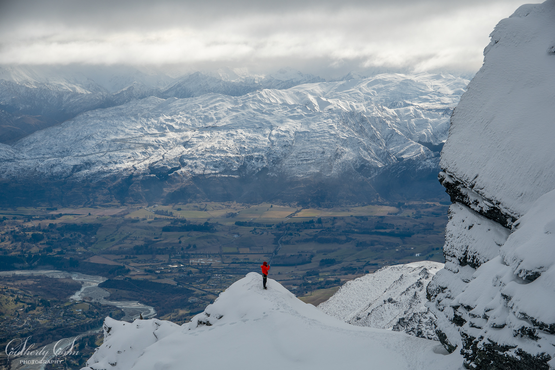 Climber in red jacket on the West Face of the Remarkables