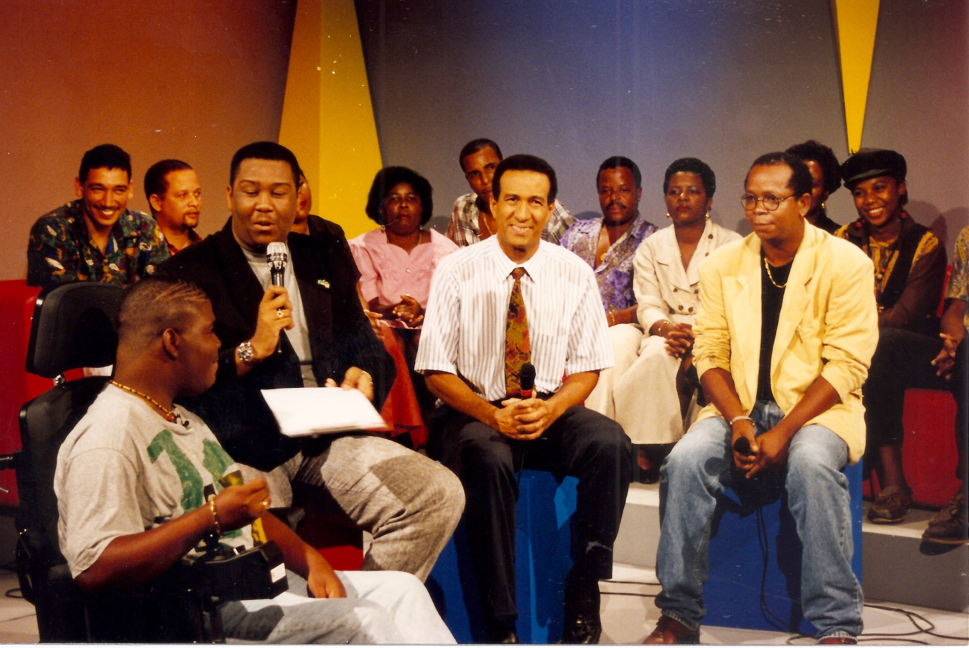Sous le regard ému de Miguel Laventure (c.) homme politique réputé, le jeune Lionel répond à David avec énergie lors du Téléthon 1994
