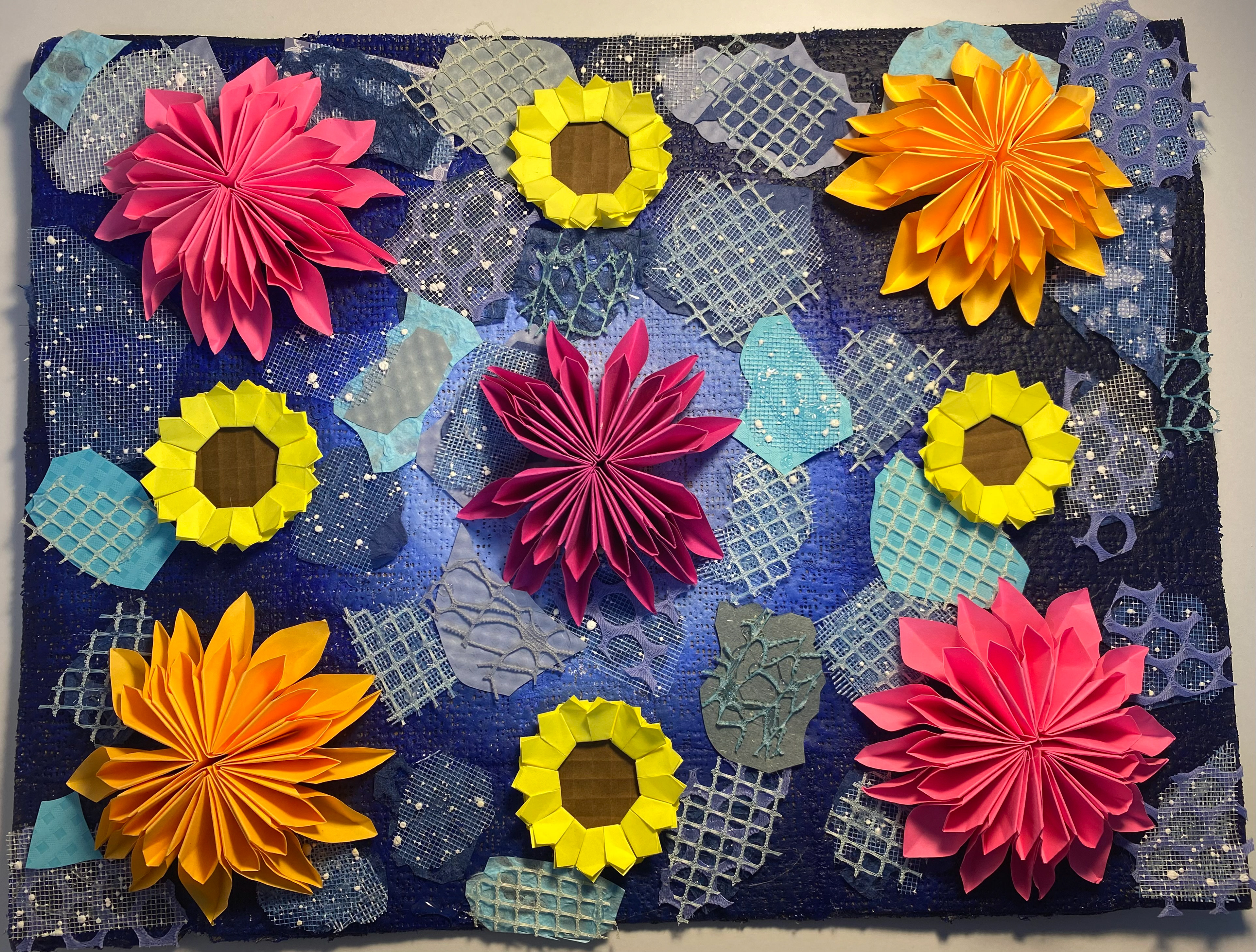 Ruby Jiminez-Menendez: I used plaster gauze for my background and painted with acrylic paint so I could add my origami chrysanthemums and sunflowers and fill the space with textured paper.