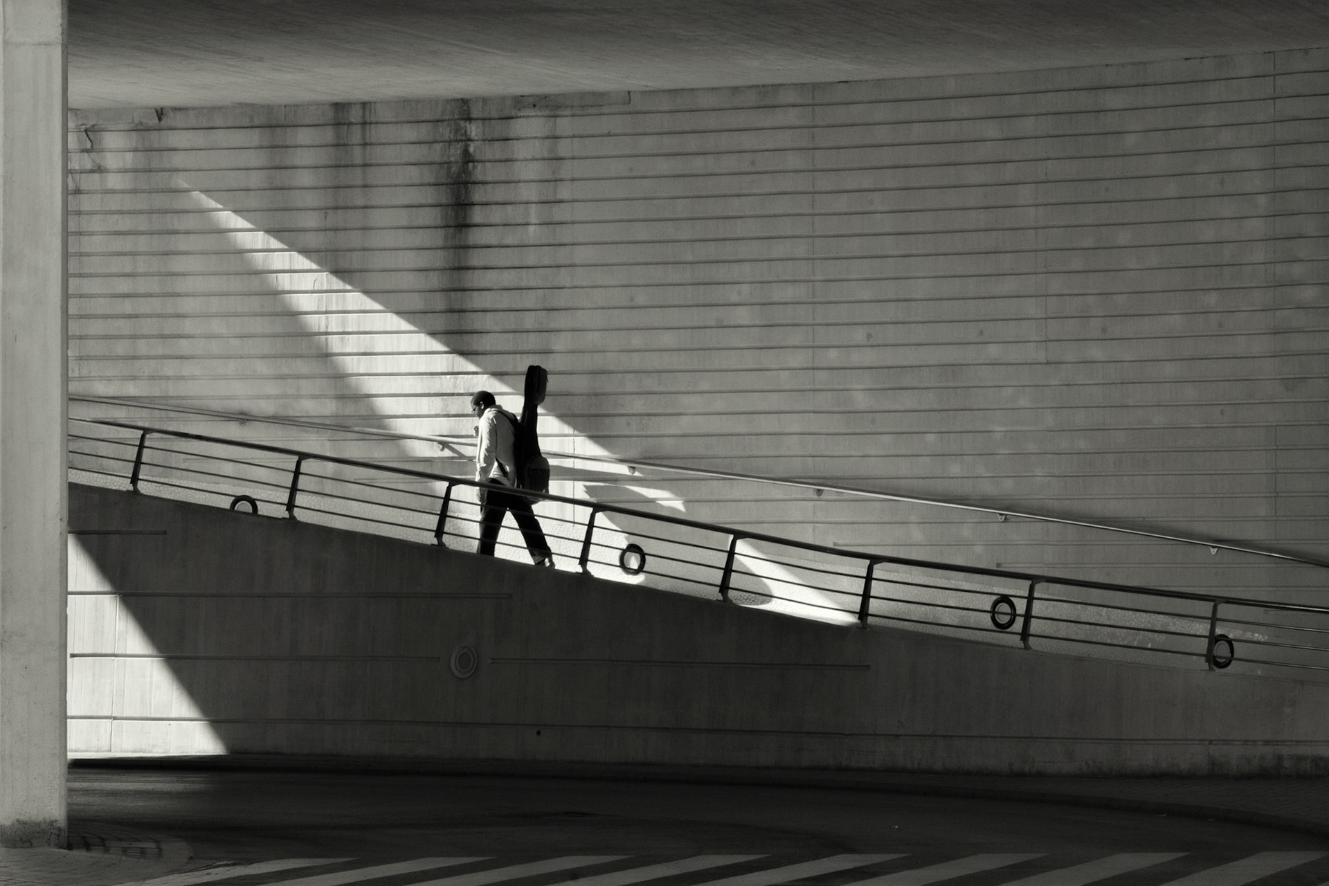 This is part of my successful ARPS panel, “Repeating Calatrava”, in which I explored Santiago Calatrava’s architectural toolkit of geometric forms.  The panel includes images taken at his City of Arts and Sciences in Valencia, Spain, Milwaukee Art Museum’s Quadracci Pavilion, USA, and the Liège-Guillemins Railway Station in Belgium.I set out to illustrate his geometry, dreams and light – often as abstract architecture but occasionally with human figures included in the compositions.  For this image I waited until the sun created the spotlight effect to mimic stage lighting. -- Submitted to the Street Photography Awards 2018 on lensculture.com