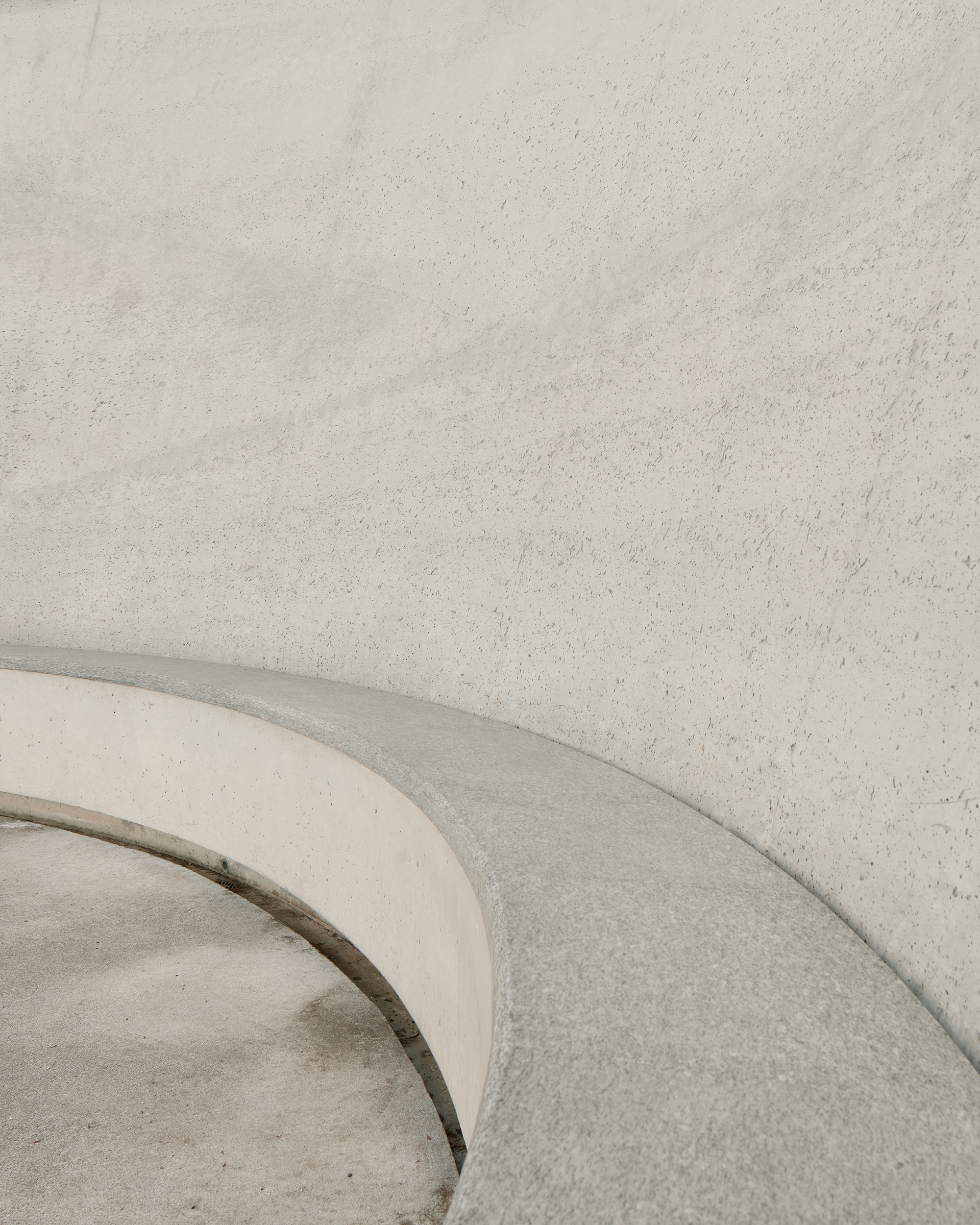 Detail at James Turrell's Skyspace right next to Hotel Castell in Zuoz, Switzerland. Highlighting the materiality the image only shows the minimalist curve of the sitting area from which visitors are invited to look up into the sky.