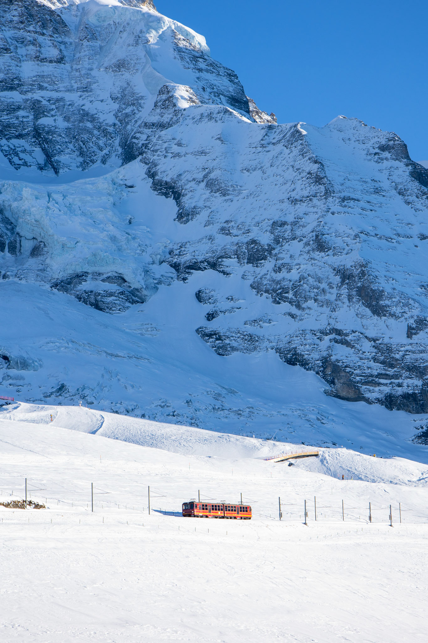 A red train is heading toward the jungfraujoch, the top of Europe. Above are the snow moutains.