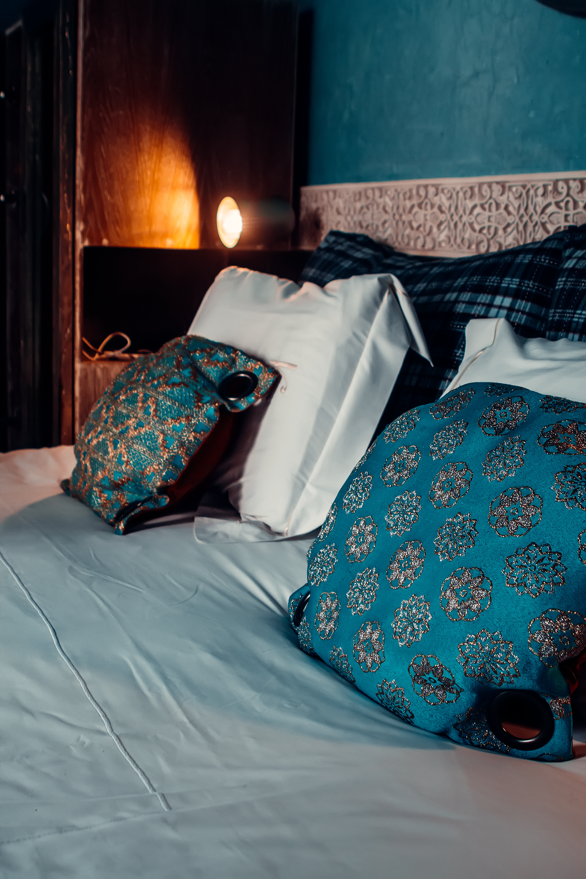  Temlyder — hotel room photography, luxury bedroom with teal Moroccan patterned bedding and warm ambient lighting