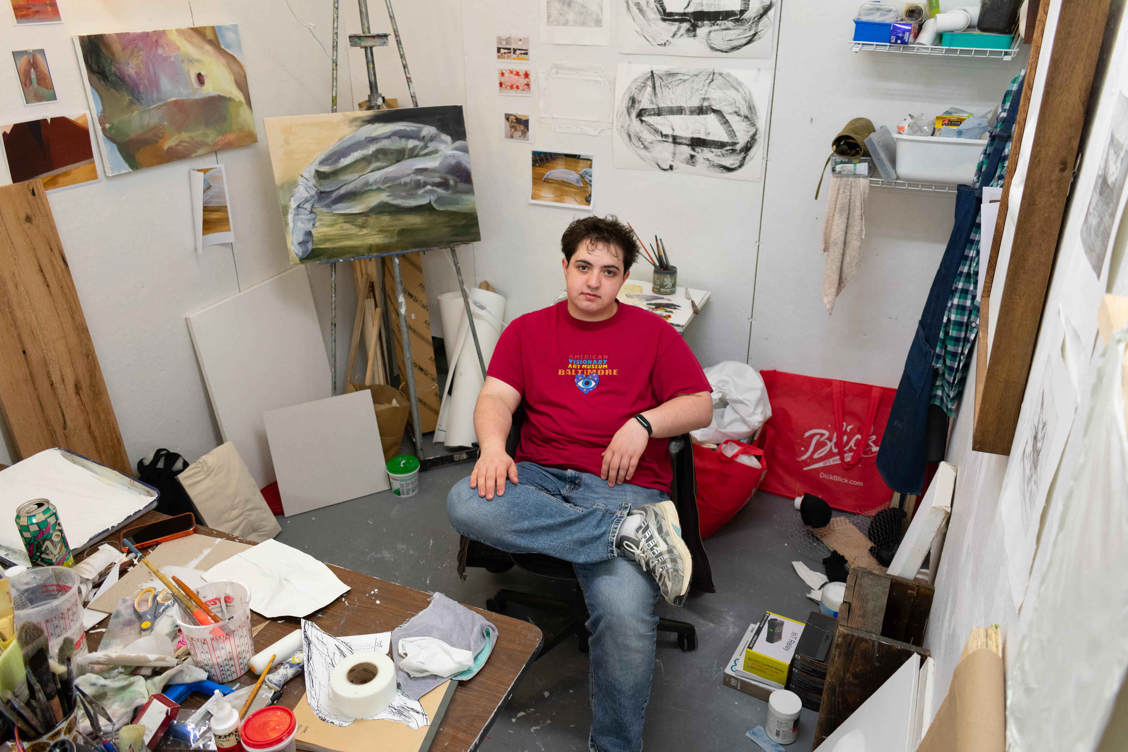 Mikey seated in his studio surrounded by both completed and in progress works