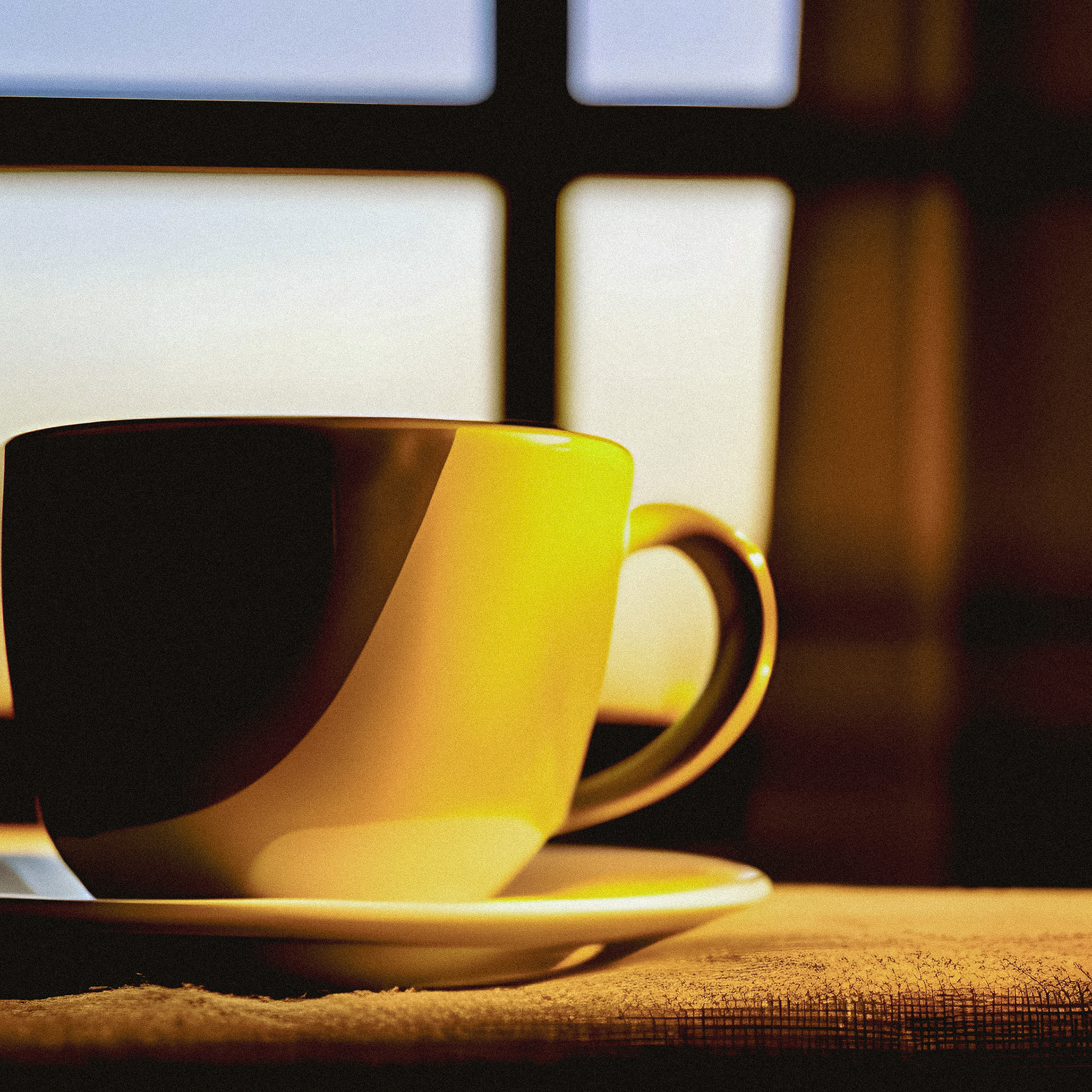 Yellow cup at a window, covered with a very harsh shadow