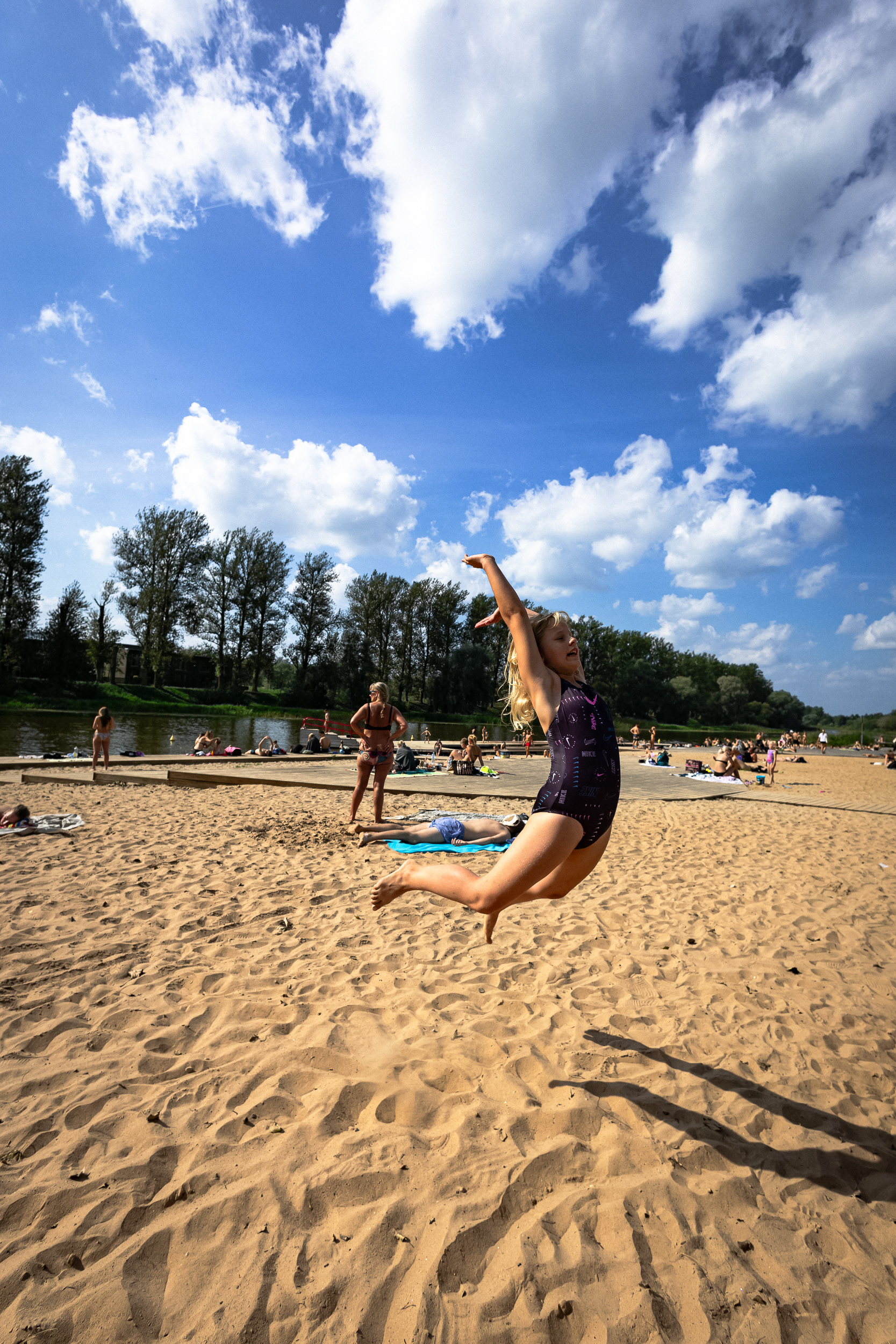 Girl standing on a beach, jumping cheerfully
