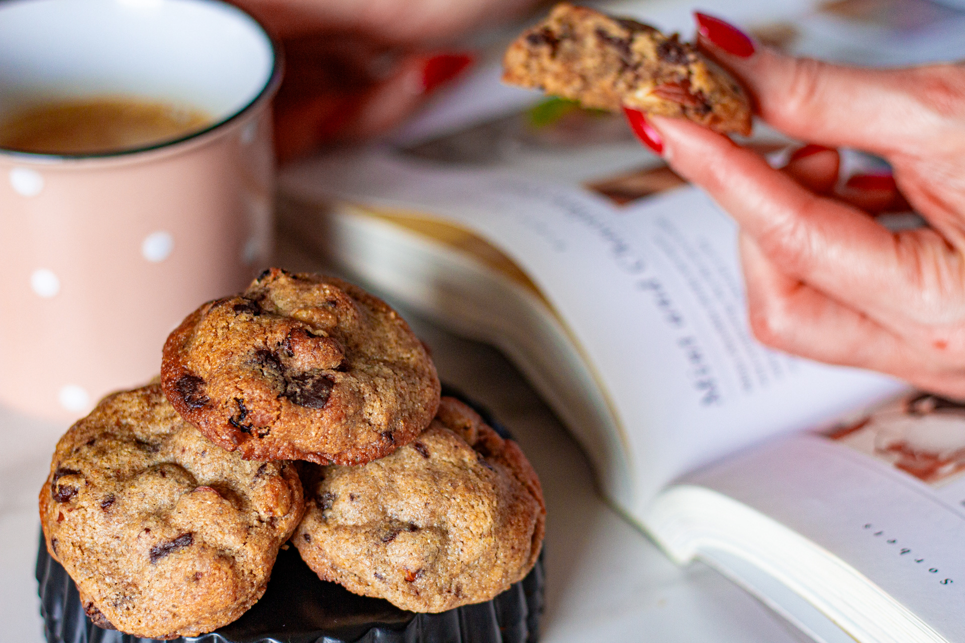 Woman holding a chocolate chip almond raisin cookie