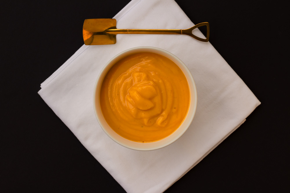Pumpkin soup with a golden spoon