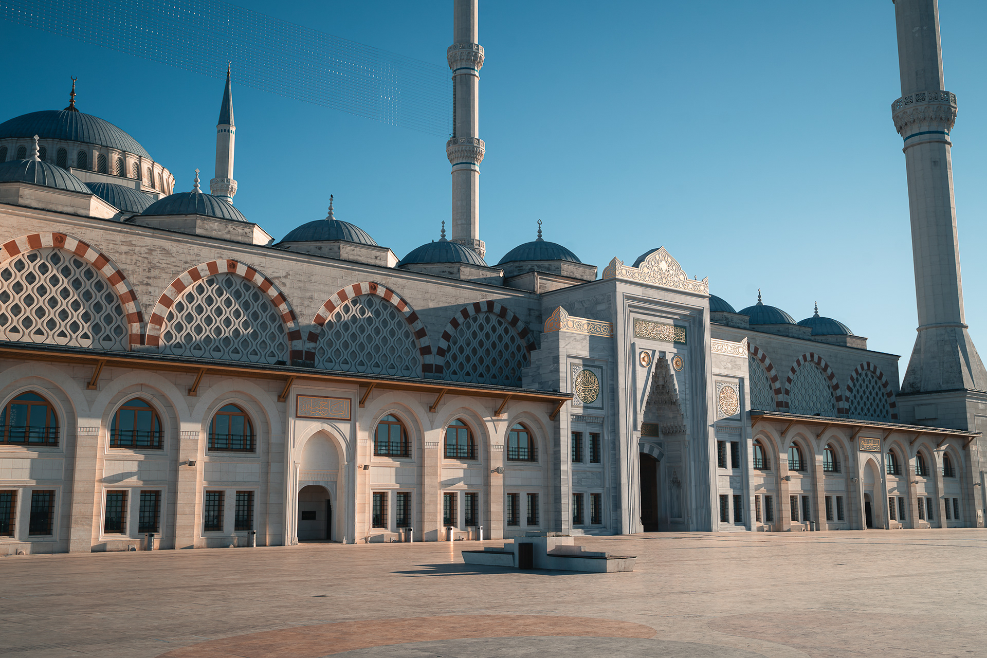 Photographie d'architecture de Sabri Kaced montrant l'esplanade et les détails des façades extérieures de la mosquée Camlica sous une lumière rasante de fin de journée.