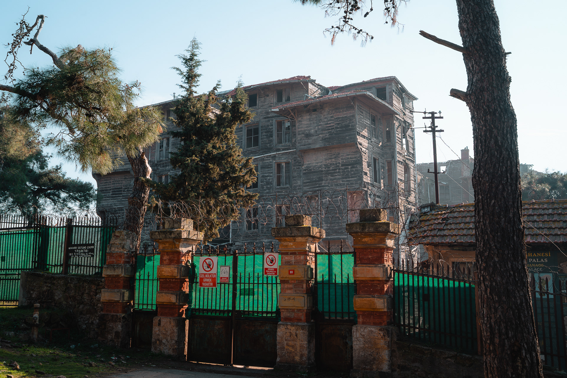 Vue de l'orphelinat grec de Prinkipo en bois massif derrière une clôture de sécurité, capturée par Sabri Kaced.