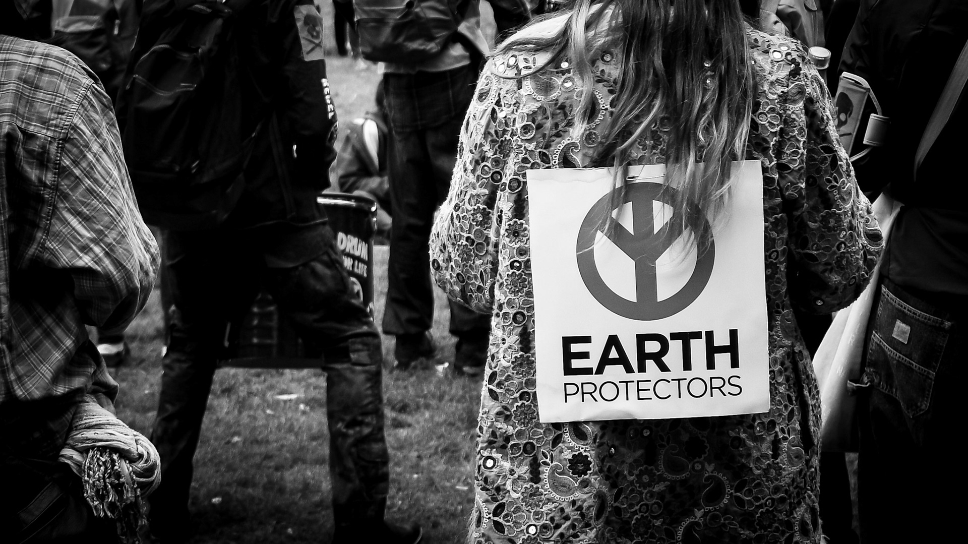 A woman wears an Earth Protectors sign on her back