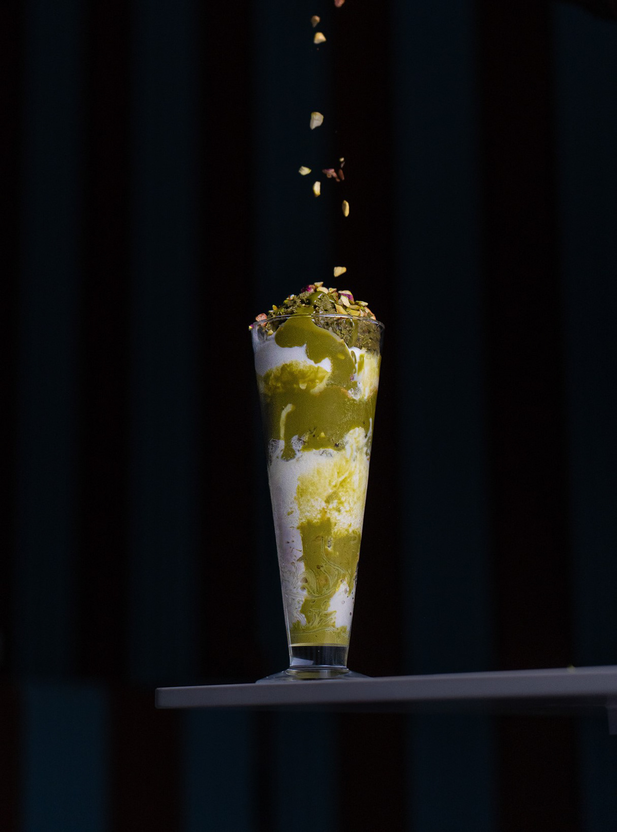 Artistic pistachio dessert photography featuring falling toppings by Ash, a professional beverage and food photographer in Toronto available for studio and on-site shoots throughout Ontario.