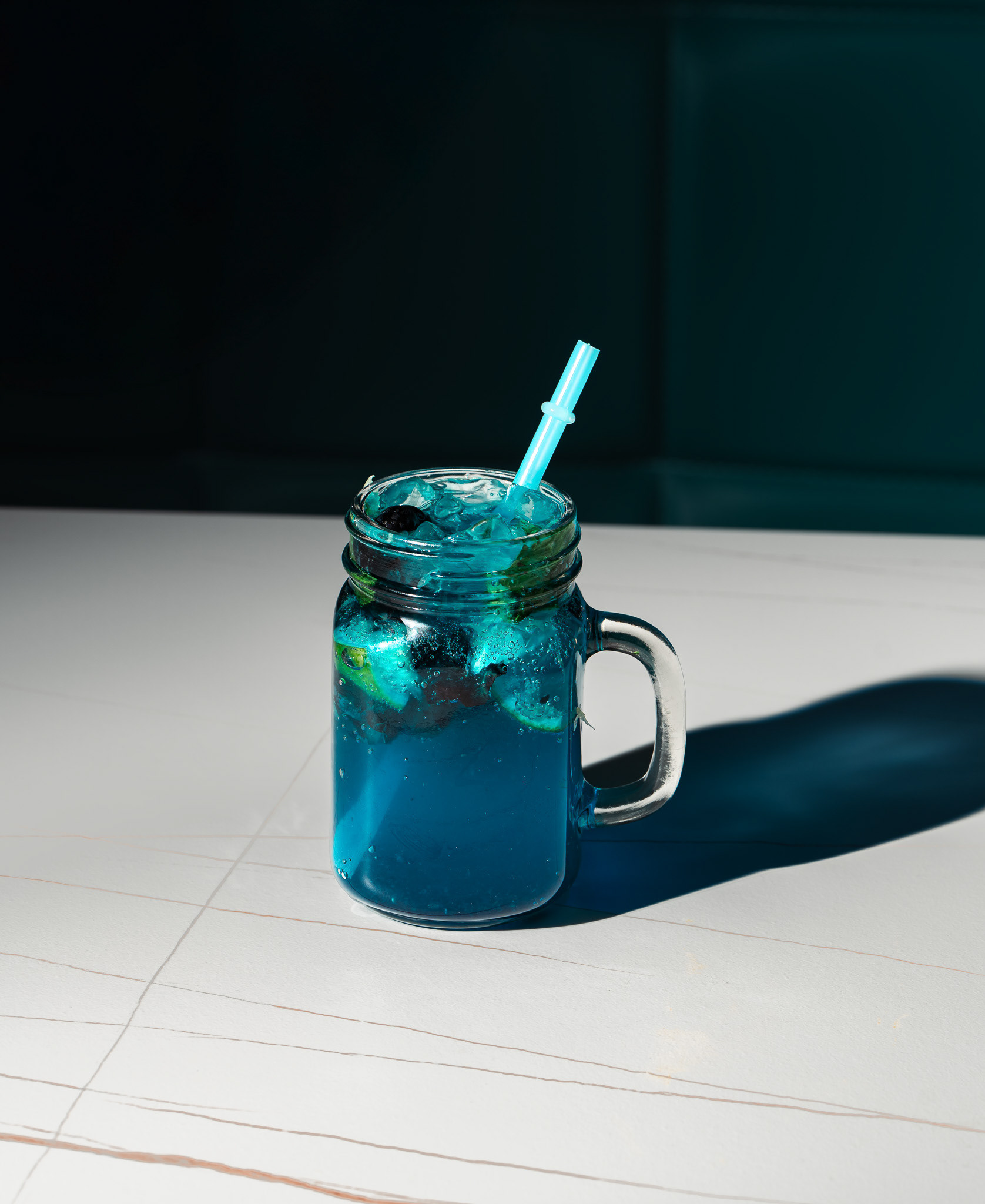 Vibrant blue summer cocktail with mint and berries, professional beverage photography by Toronto-based food photographer Ash, serving clients in Ontario and nationwide.