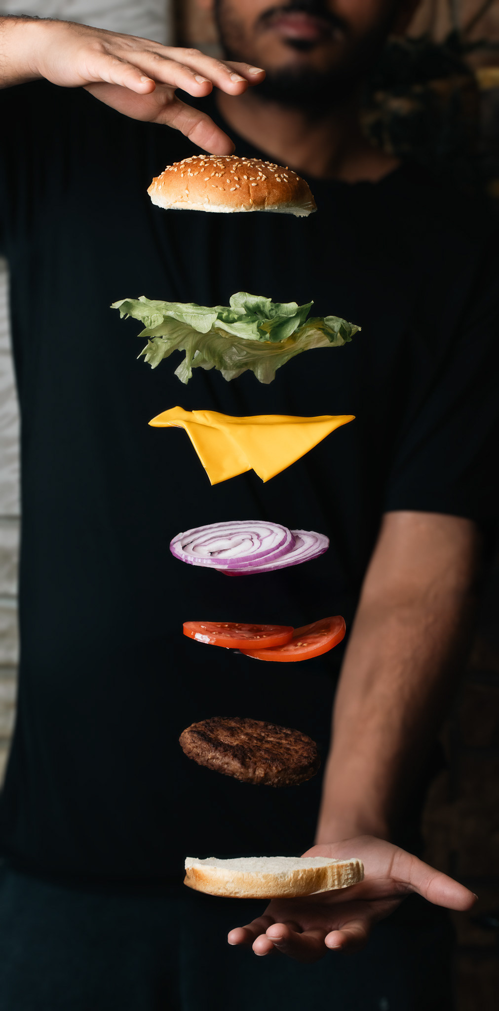 The image shows the contents of a burger all aligned in air, captured by a food photographer in Toronto and near me. It makes use of shadows in food photography. Food photography Tutorial for beginners, A complete guide to capturing your food photos or for social media content creation, reels creating imagery, Instagram reels and facebook food photographer