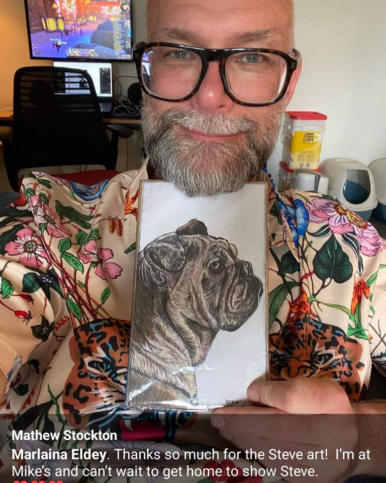 Mathew Stockton, co-host of the Dark Poutine Podcast, posing with a drawing I made of his bulldog, Steve.