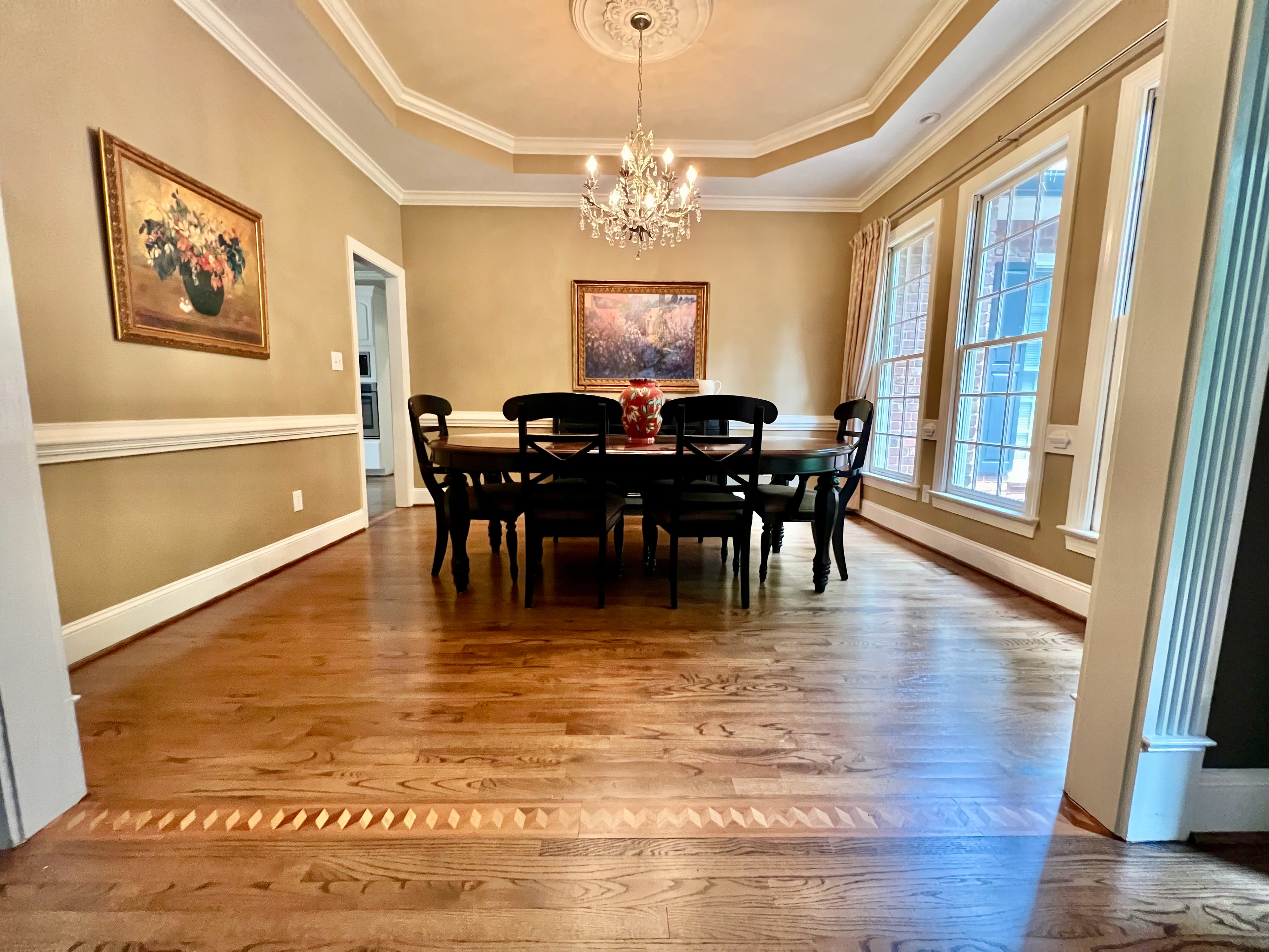 Formal dining room with tray ceiling and custom inlaid wood border