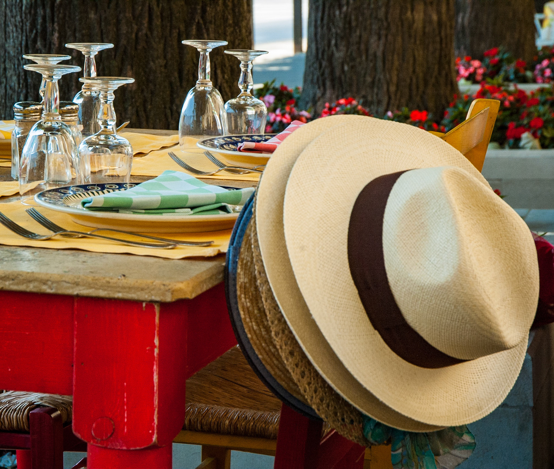 A stack of hats hang on the back of a chair at an outdoor café in Fiesole, Italy. May, 2005