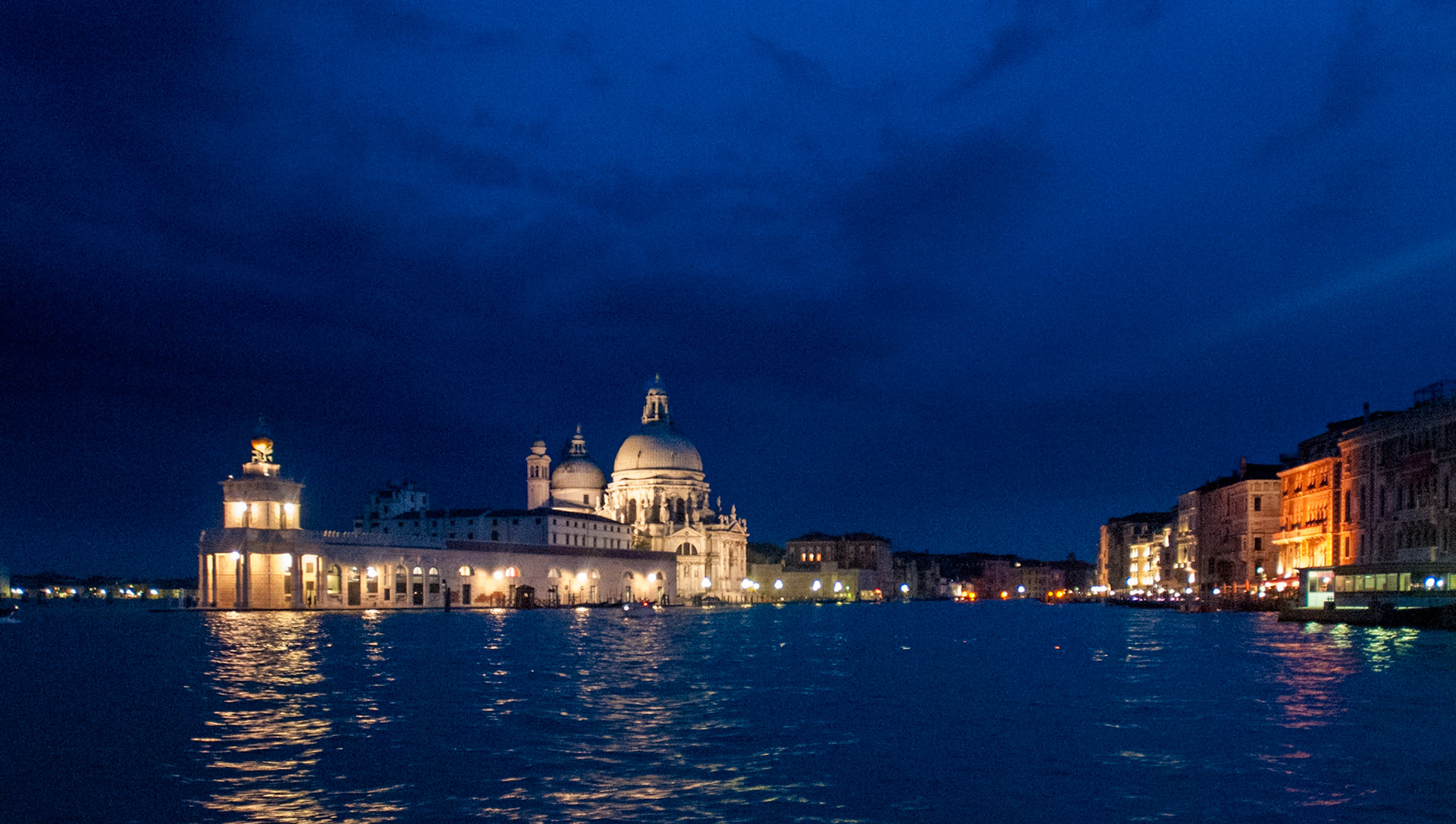The Basilica Santa Maria della Salute shines brightly from its side of the opening of the Grand Canal into the lagoon. June 2009