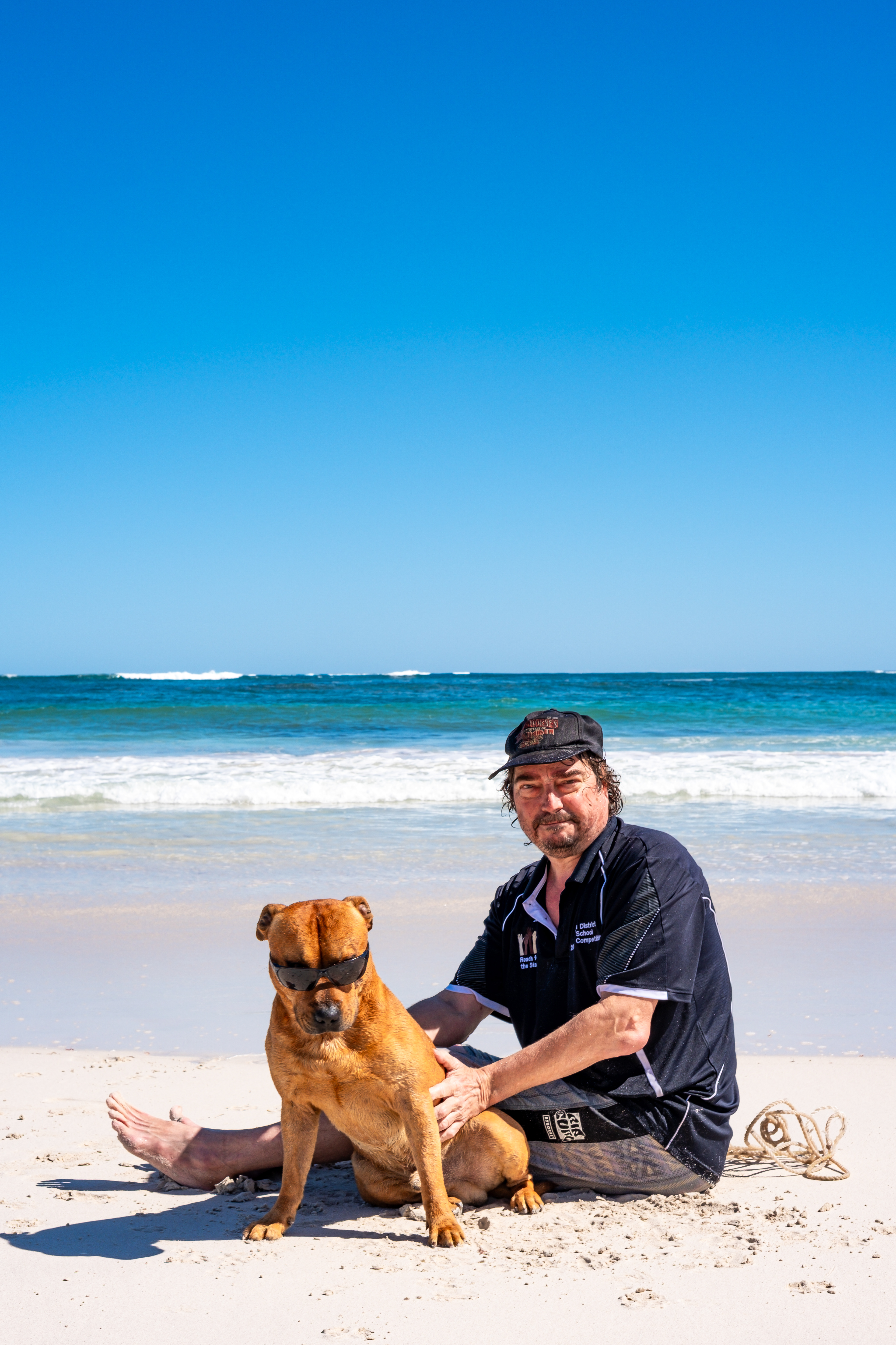 Lifestyle beach photography with a staffy dog and his owner in Western Australia.