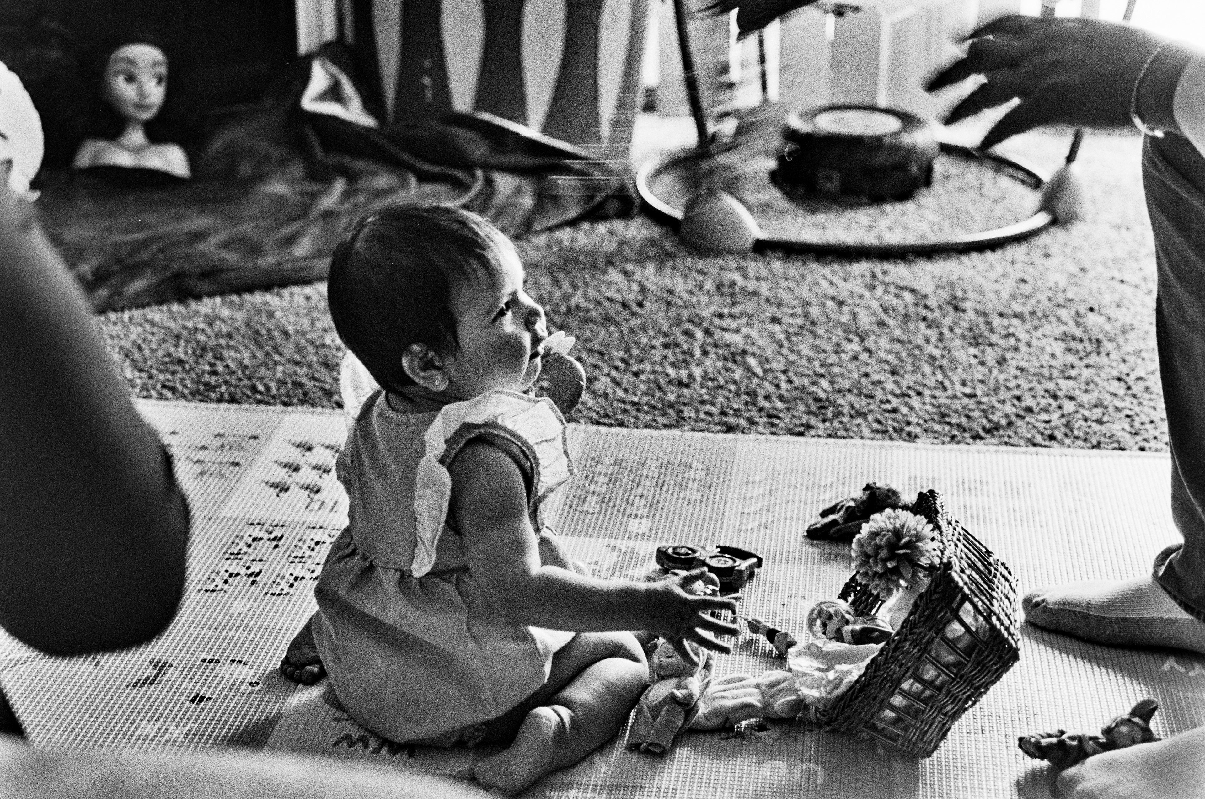 Camilla, the infant in the Hernández, gazes at her father while playing toys.