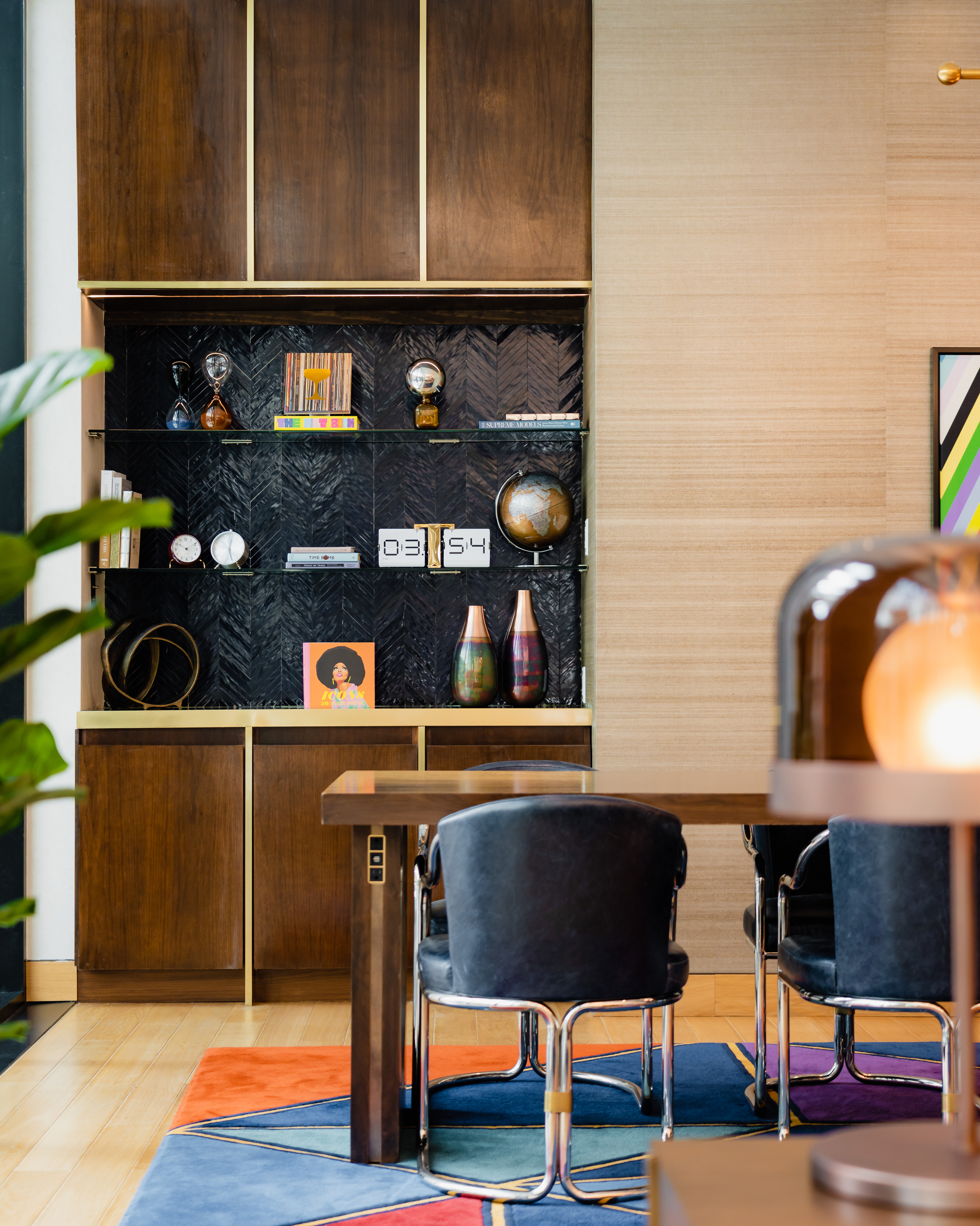 Editorial style photo of a decorated accent wall, meeting table, and decorative plant.