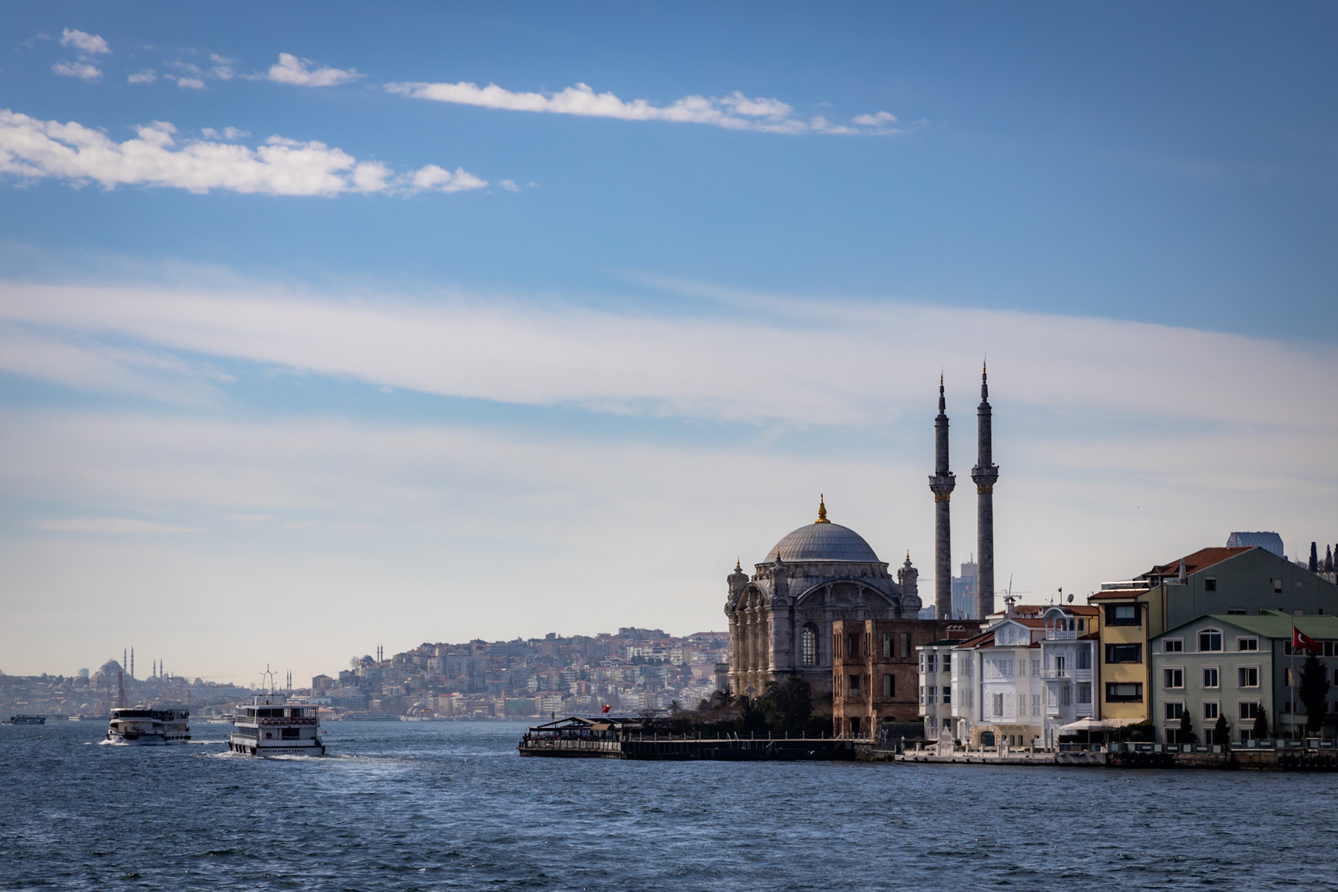 Istanbul, Turkey - March 7 2020: View on the Ortaköy mosque with the city of Istanbul on the background. Built in 1854 on the shores of the Bosphorus, next to the 15 July Martyrs Bridge, which connects Europe to Asia.